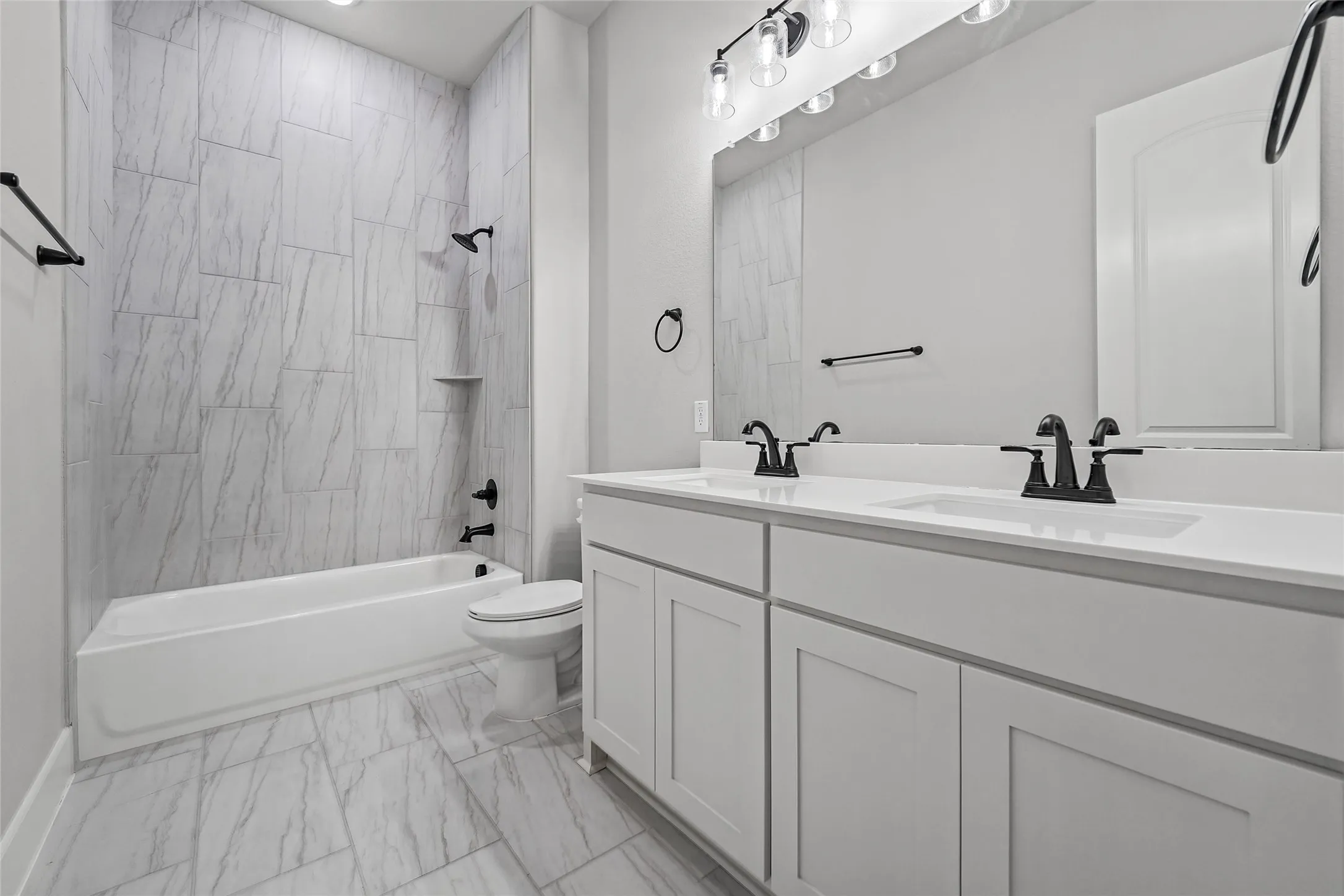 Double vanity with integrated sinks, white cabinetry, and matte black fixtures
