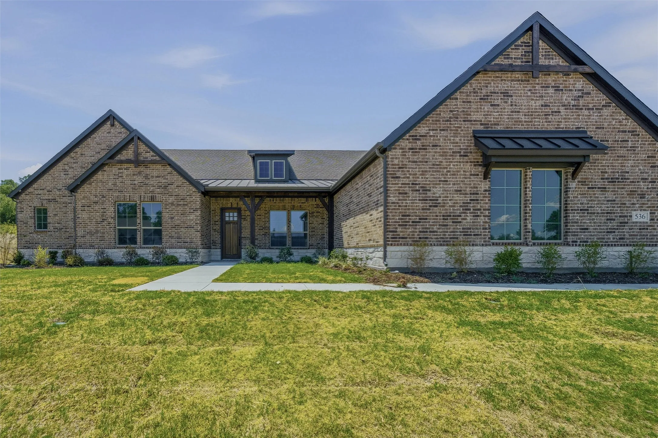 Brick exterior with stone accents, dark trim, and a prominent front gable