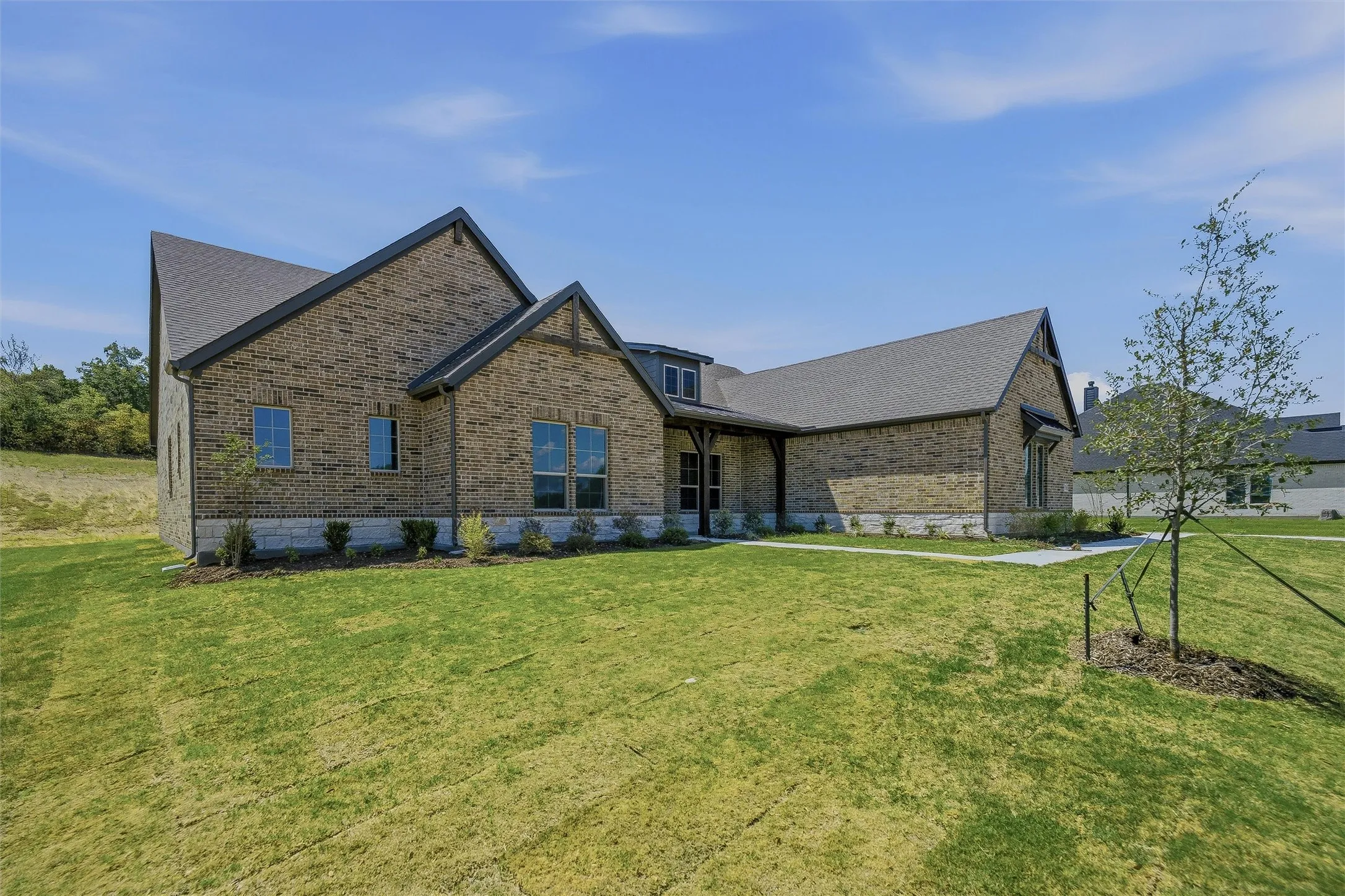 Brick exterior with stone accents, dark trim, and a gabled roofline