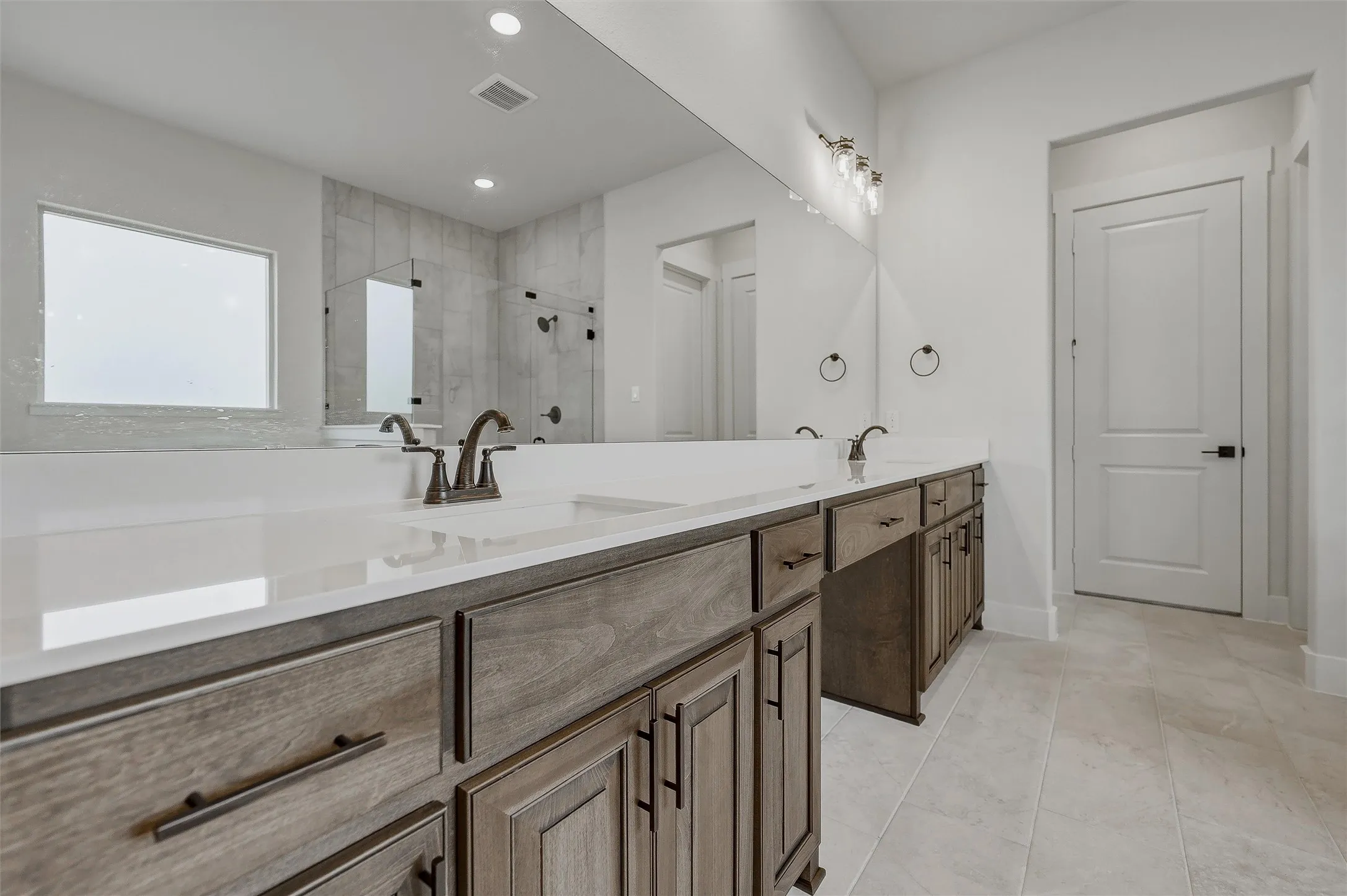 Dual vanity with undermount sinks, stone-finish countertop, and wood-finish cabinetry