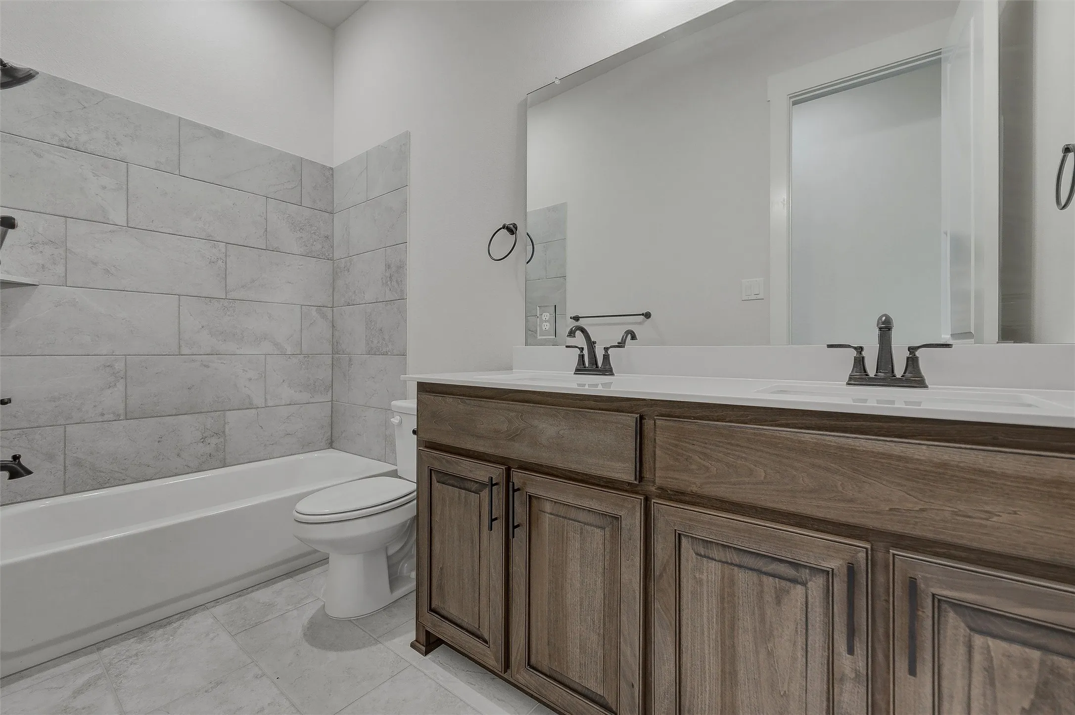 Dual vanity with undermount sinks and dark wood-finish cabinetry