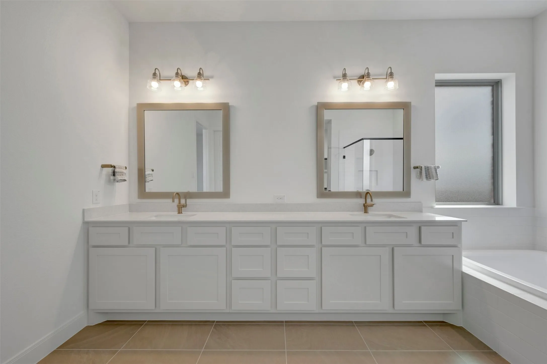 Dual vanities with white shaker cabinetry, individual mirrors, and bronze-finish fixtures