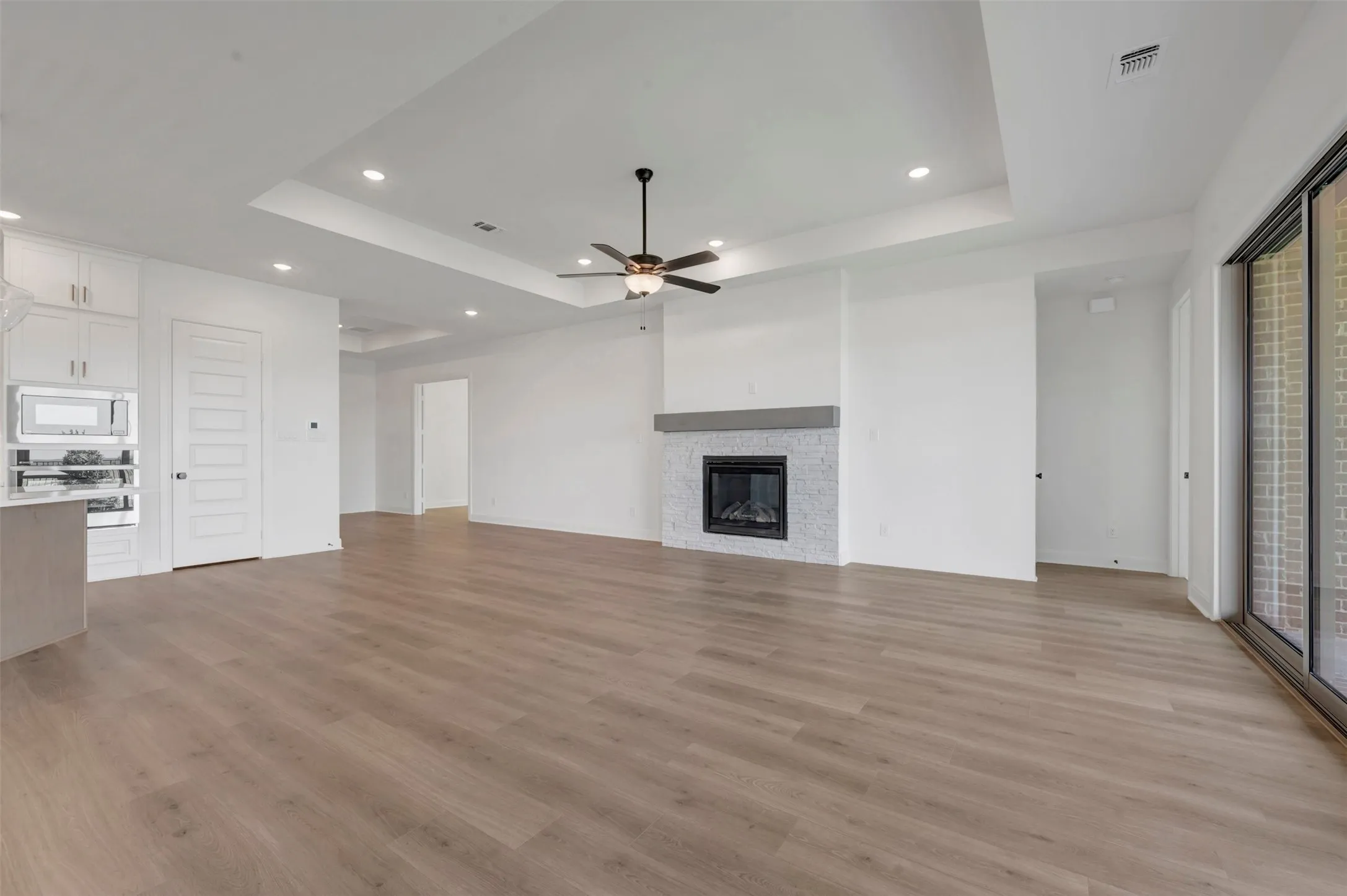 Open-concept living space featuring wide-plank wood-finish flooring, recessed ceiling lighting, and a ceiling fan