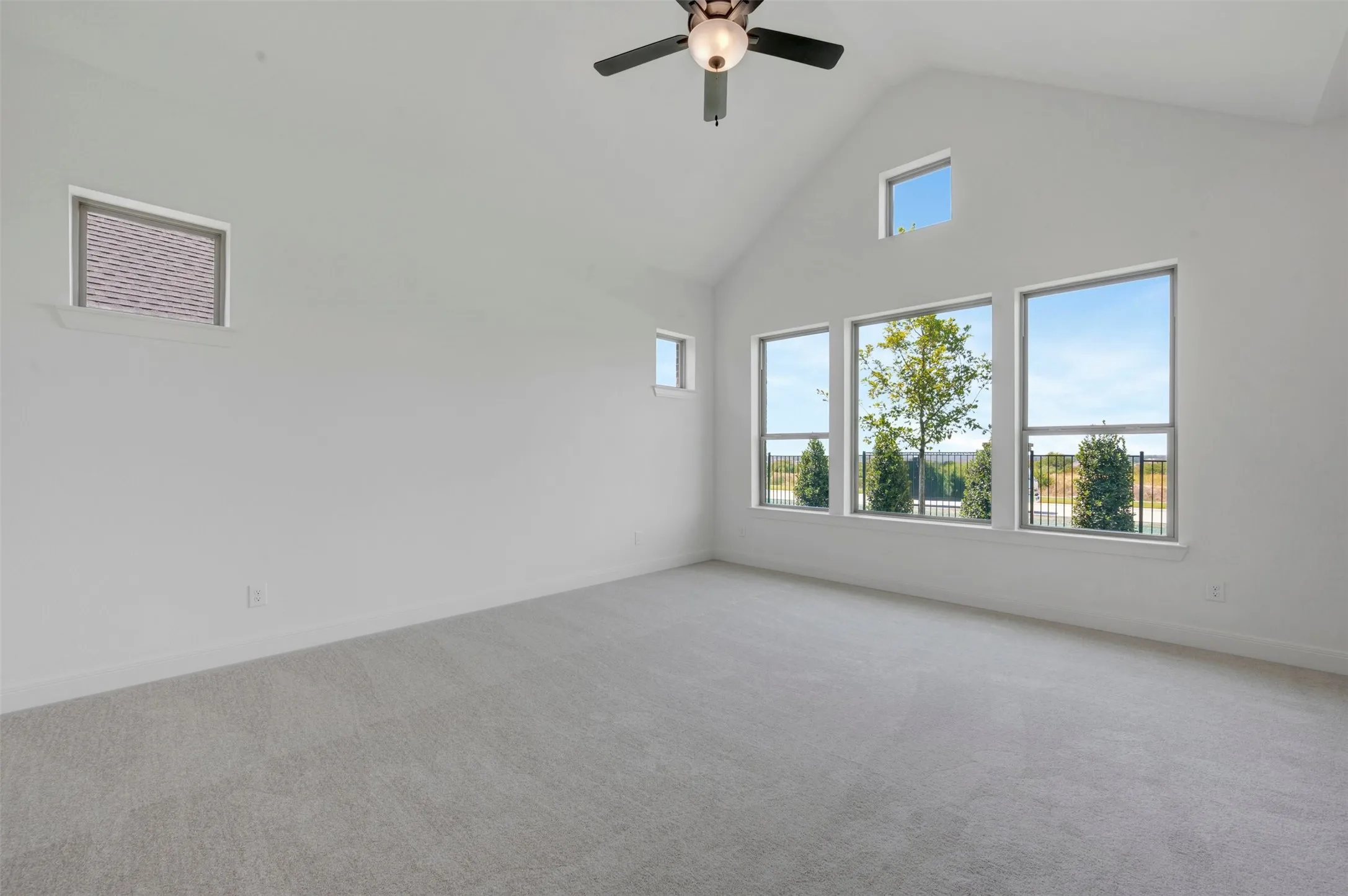 Bright and spacious upper-level room flooded with natural light through multiple large windows framing scenic outdoor vistas