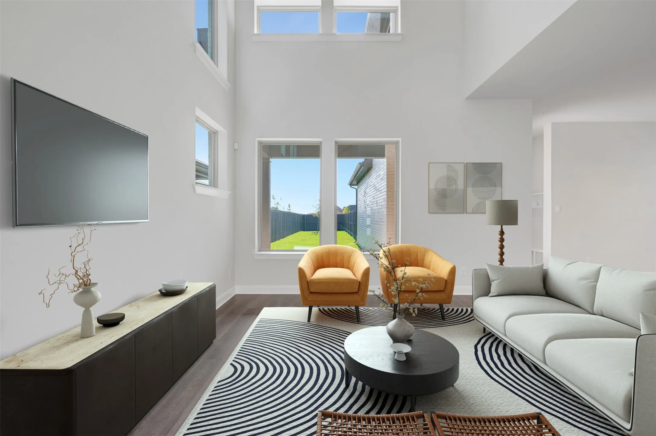 Vaulted ceiling living area featuring wood-finish flooring, white walls, and multiple windows
