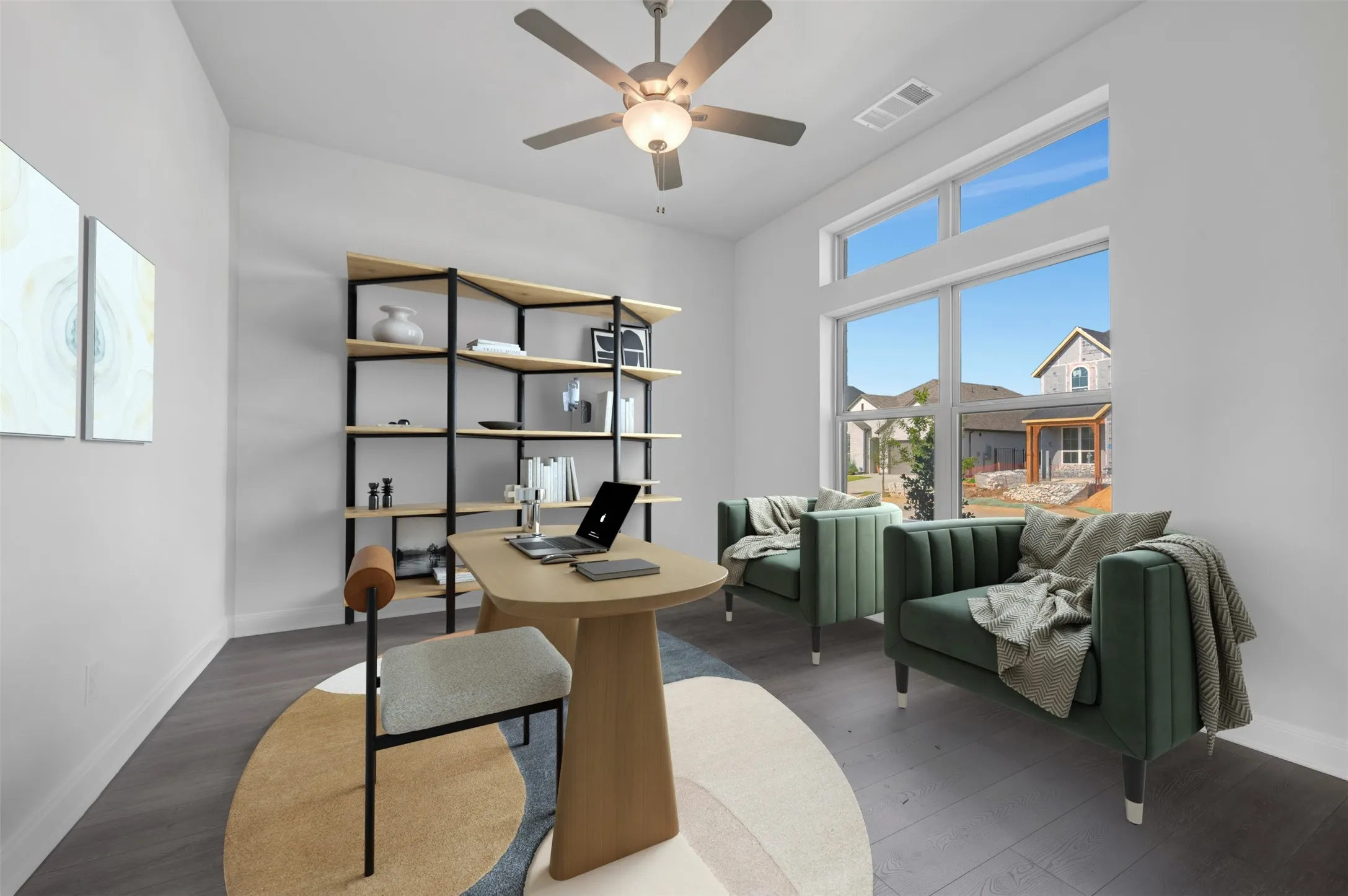 Room featuring high ceilings, large windows with transom panels, dark wood-finish flooring, a ceiling fan with integrated lighting, and built-in shelving