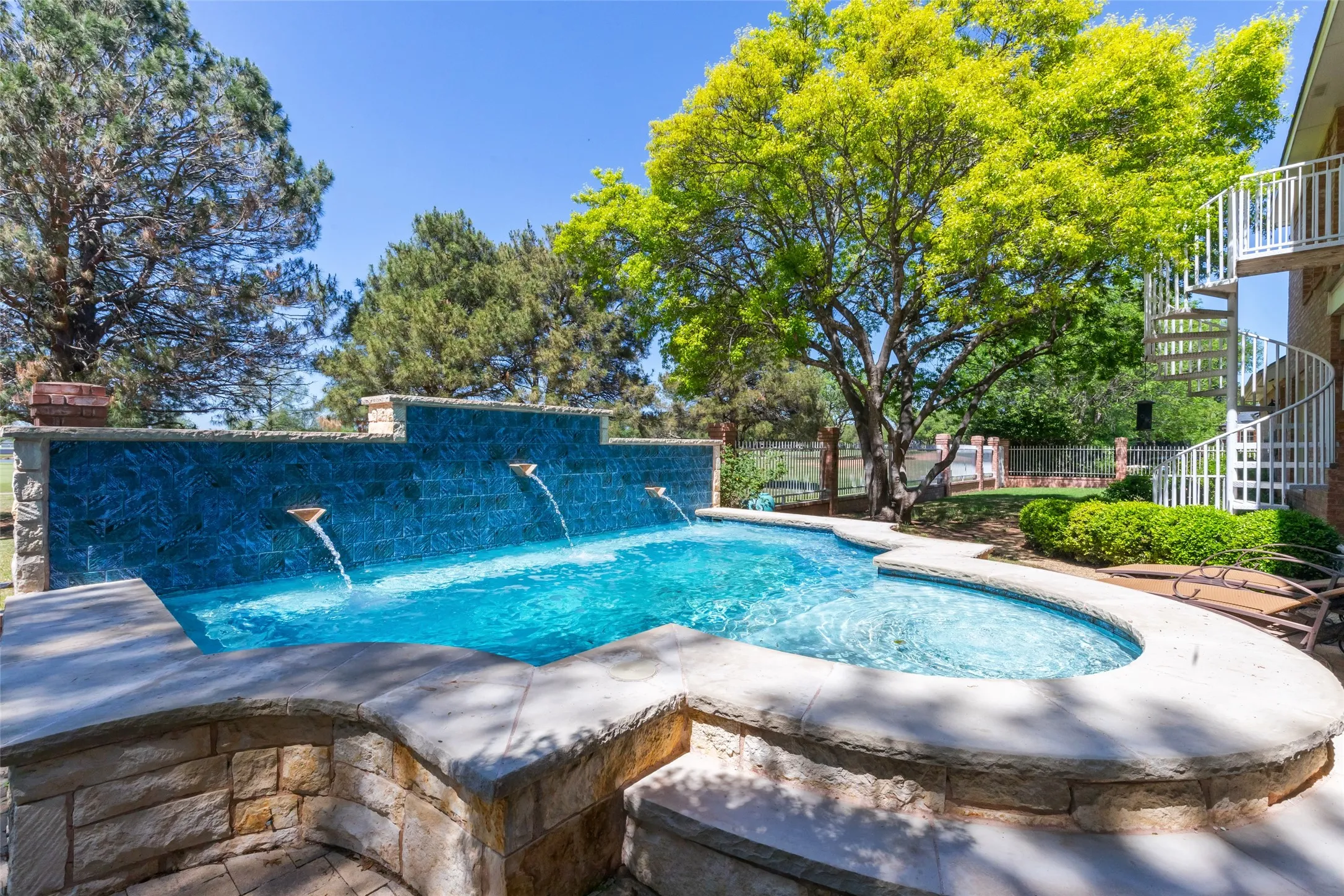 Spool with wrap around tanning ledge and water feature.