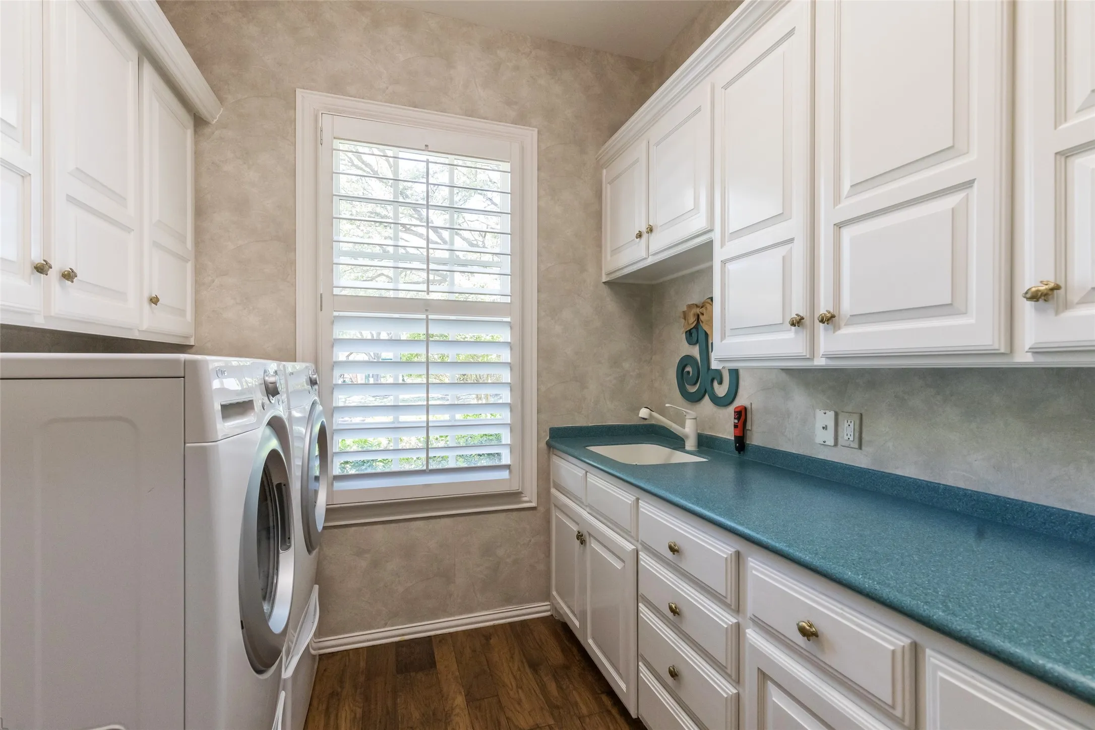 Laundry room with plenty of cabinets, sink and drip dry area.