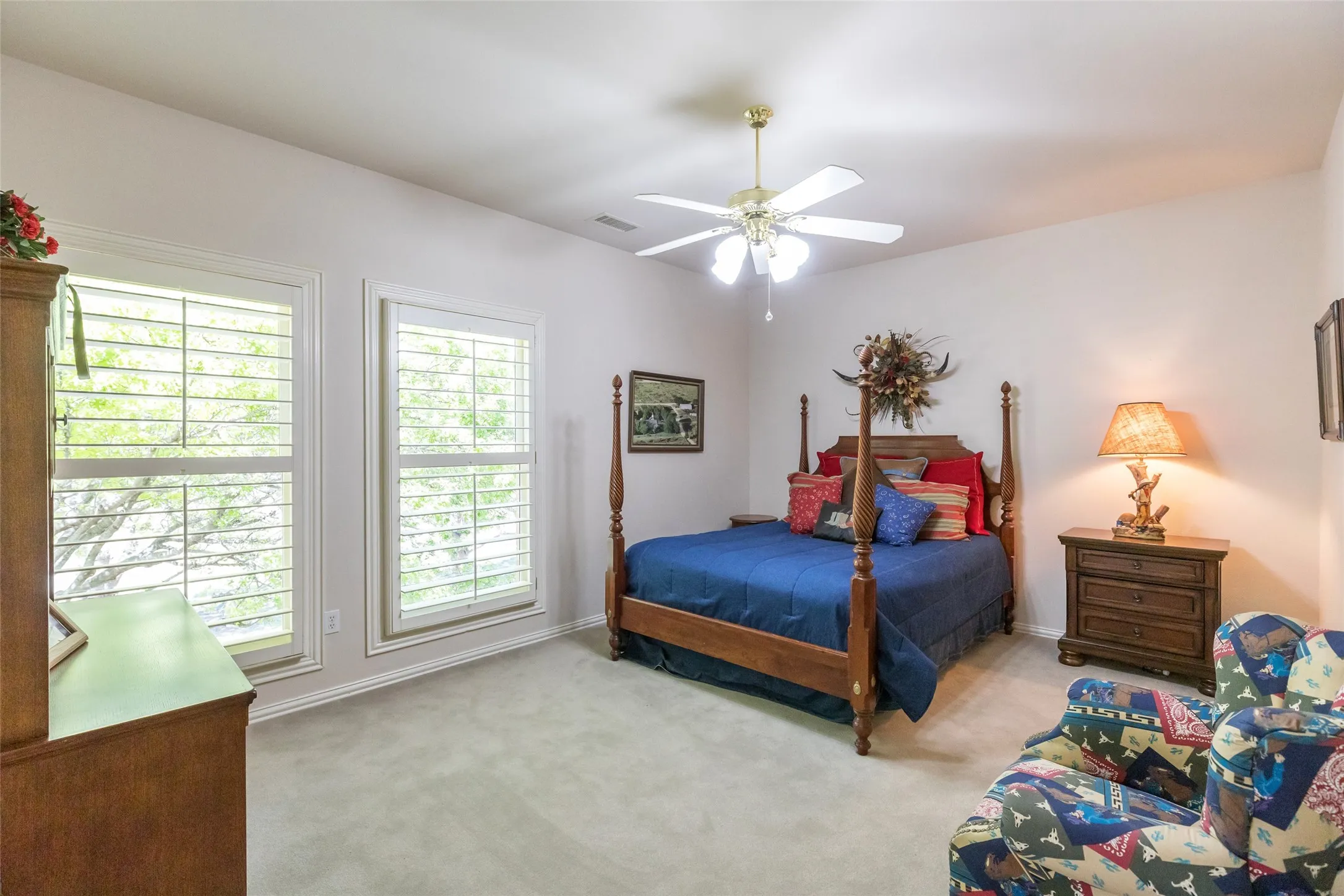 Upstairs bedroom with plantation shutters and access to upstairs covered porch and balcony.  Private en suite bath and walk in closet.