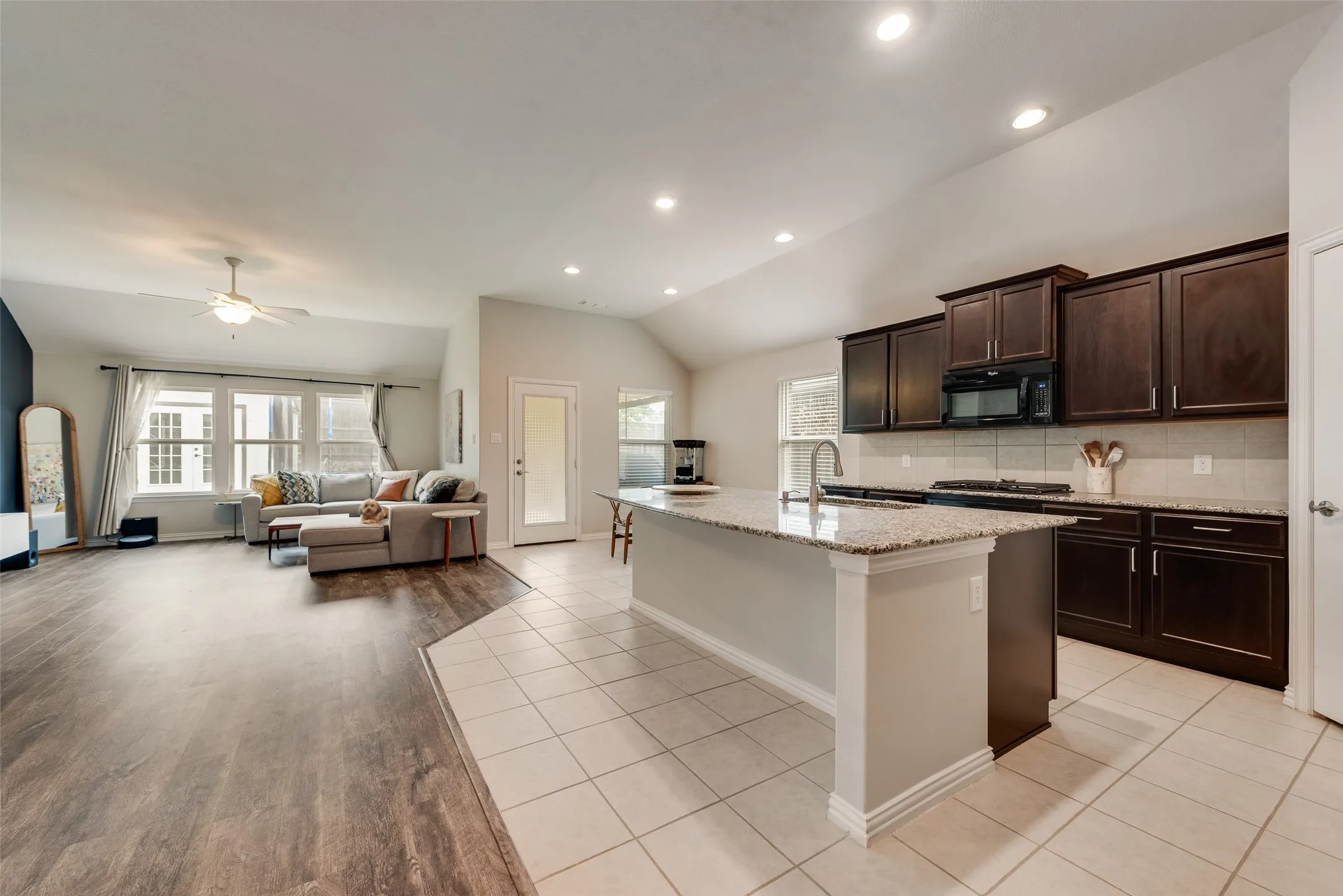 Spacious kitchen with oversized island and granite countertops open to the living and dining areas at 1432 Westview Ln in the Canyon Falls community in Northlake, TX