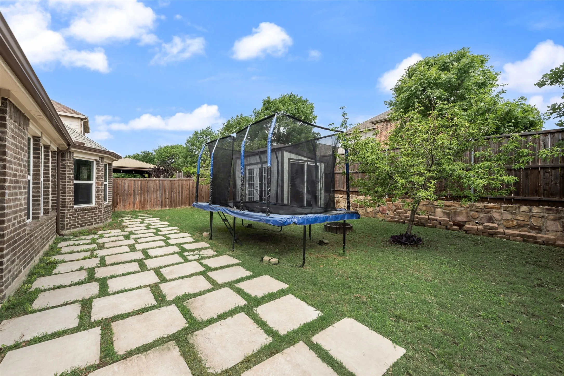 Backyard with concrete pavers and storage shed at 1432 Westview Ln in the Canyon Falls community in Northlake, TX