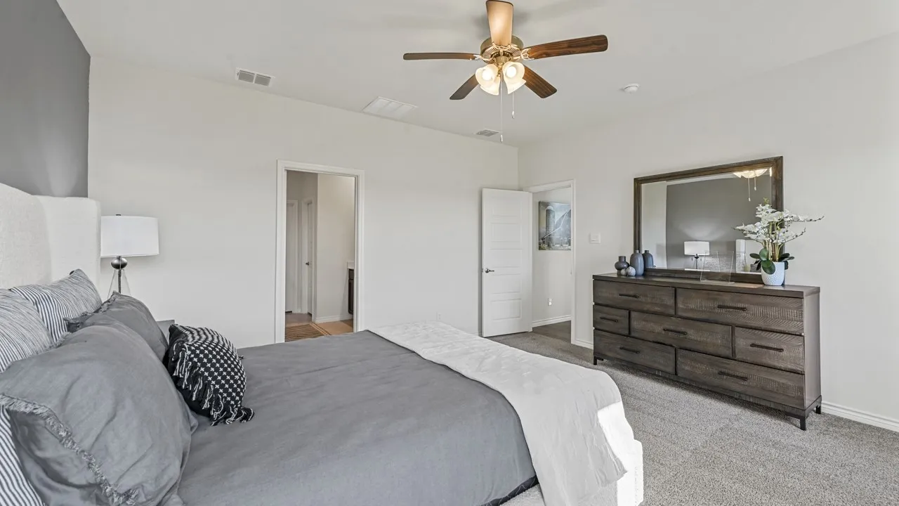 Spacious room featuring vaulted ceilings, a ceiling fan with integrated lighting, and light-toned carpeting