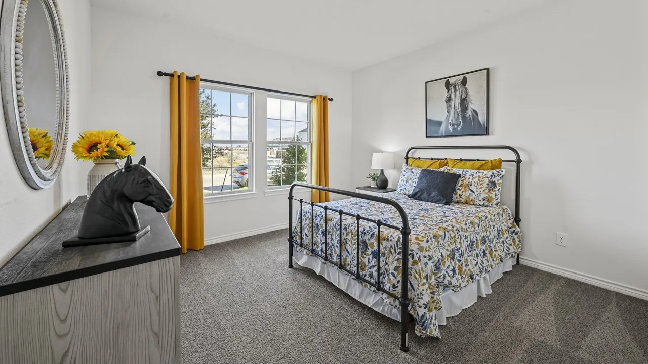 Bright bedroom featuring two large windows, neutral wall color, and grey carpet flooring
