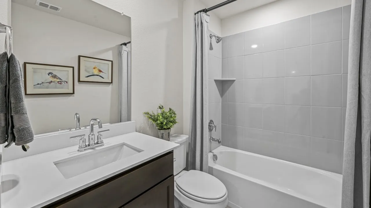 Bathroom featuring a single vanity with an integrated sink, polished chrome faucet, and dark wood-finish cabinetry