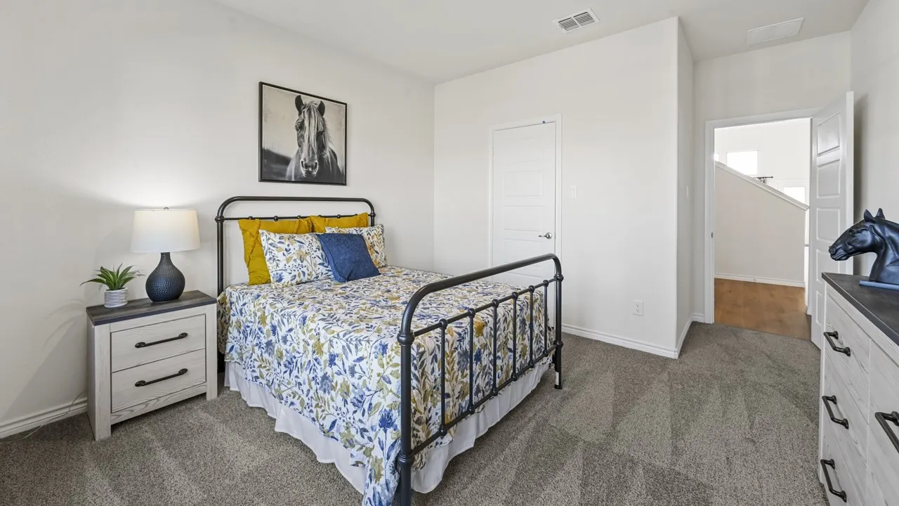 Bedroom featuring plush gray carpeting, white walls, and a solid core interior door