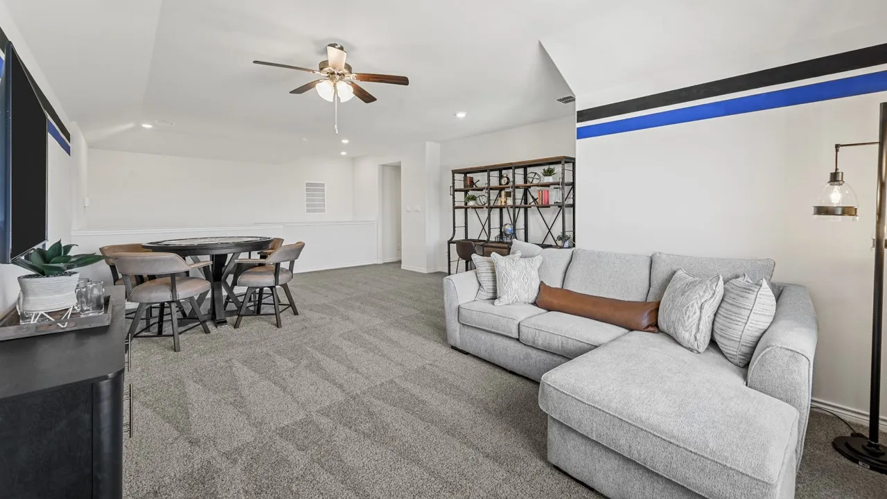 Carpeted loft area featuring a ceiling fan, recessed lighting, and a partial wall overlooking a lower level