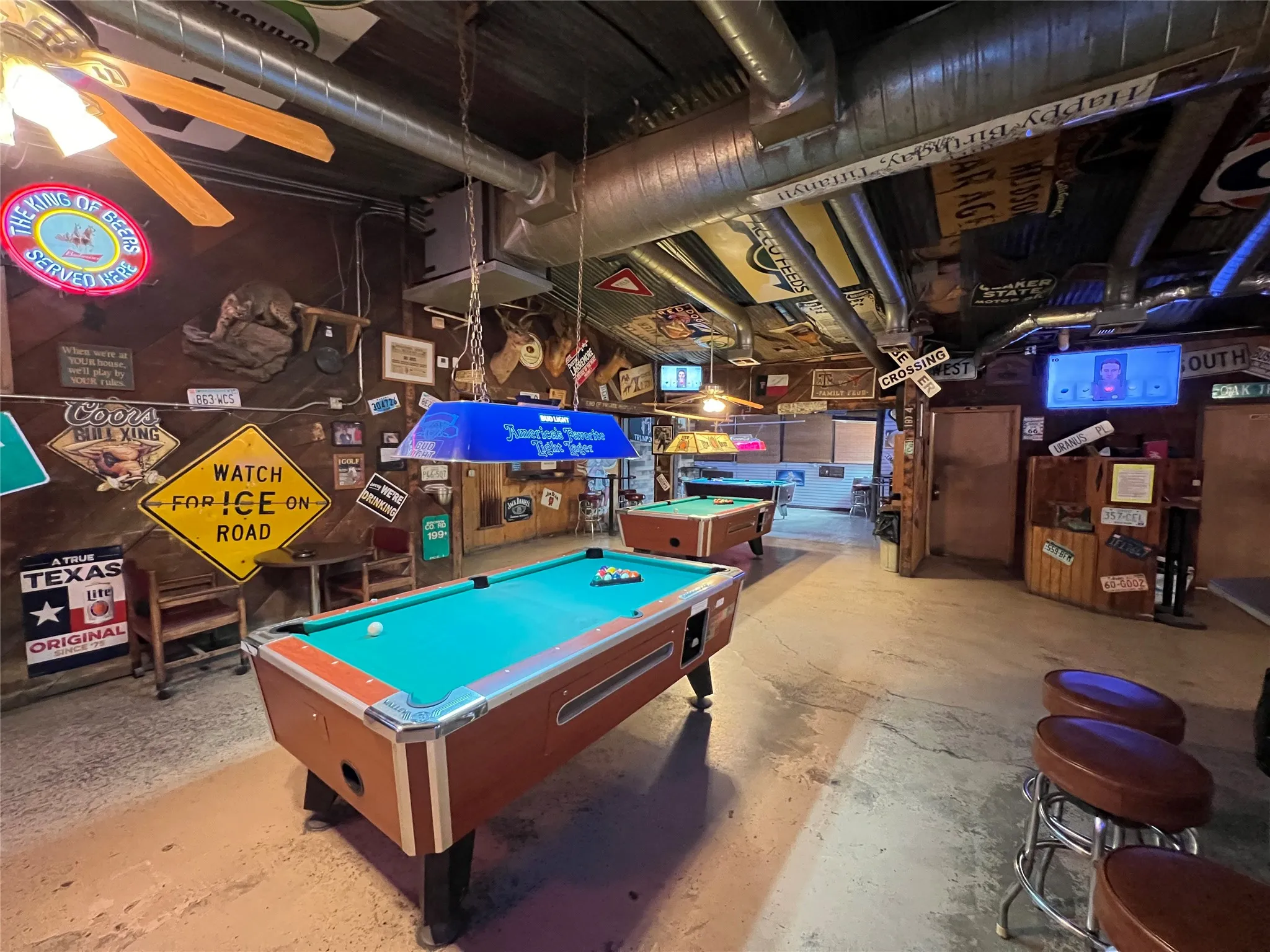 Recreational space featuring two pool tables with overhead lighting