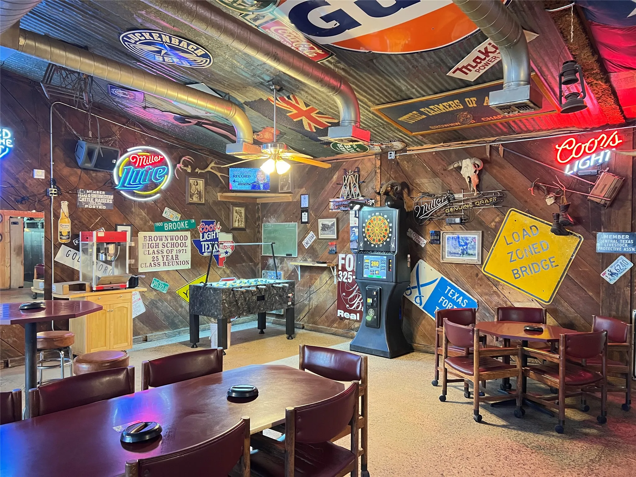 Recreational room featuring wood-finish wall paneling and a corrugated metal ceiling