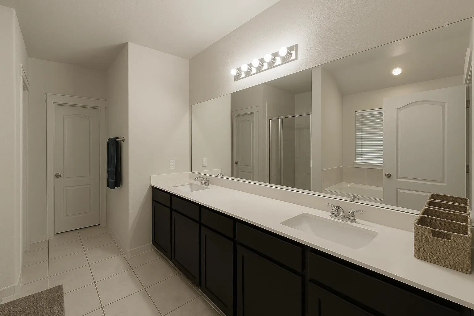 Double vanity with integrated rectangular sinks, white countertops, and dark wood-finish cabinetry