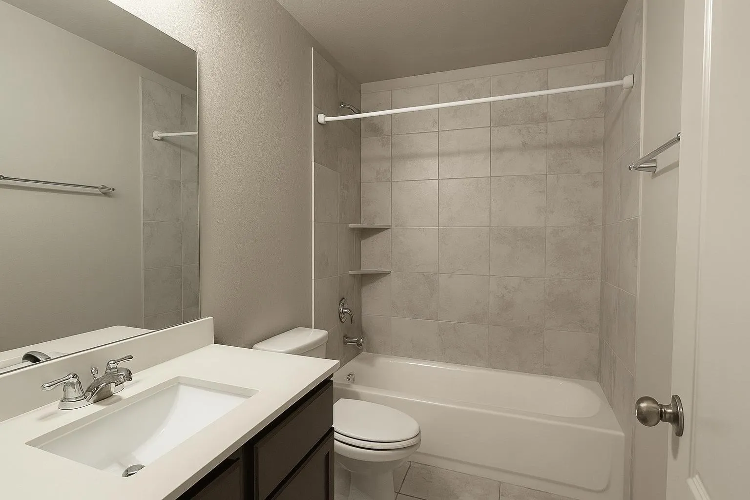 Bathroom featuring a white integrated sink, chrome faucet, and dark wood-finish vanity with drawer storage