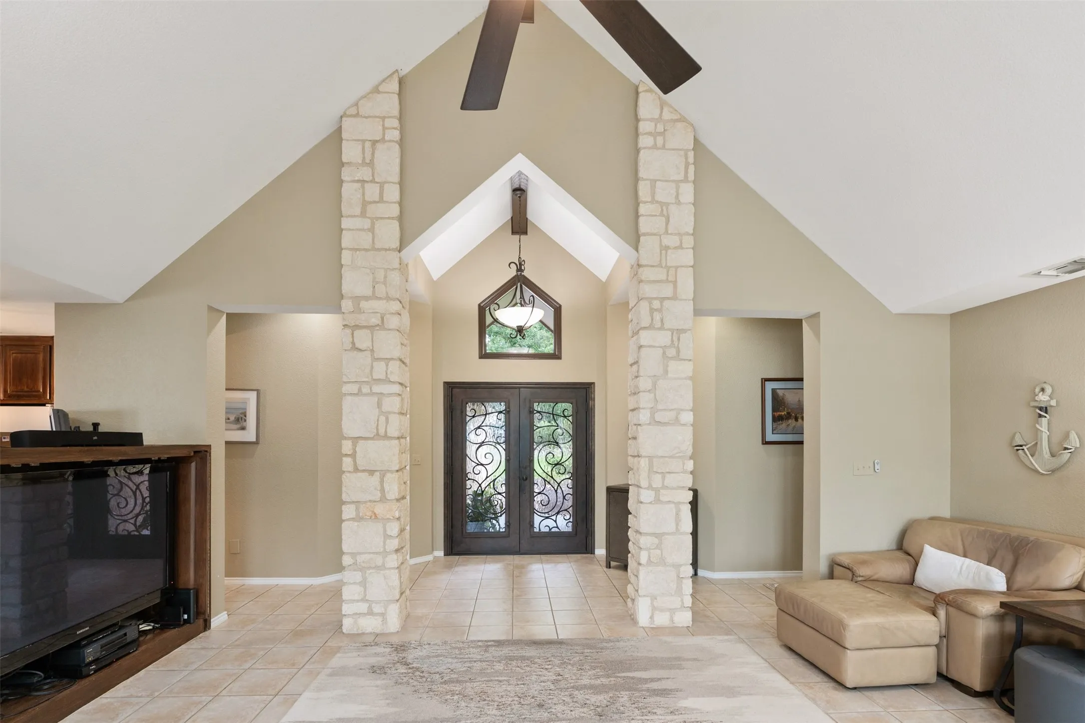Vaulted ceilings featuring exposed beams and a ceiling fan