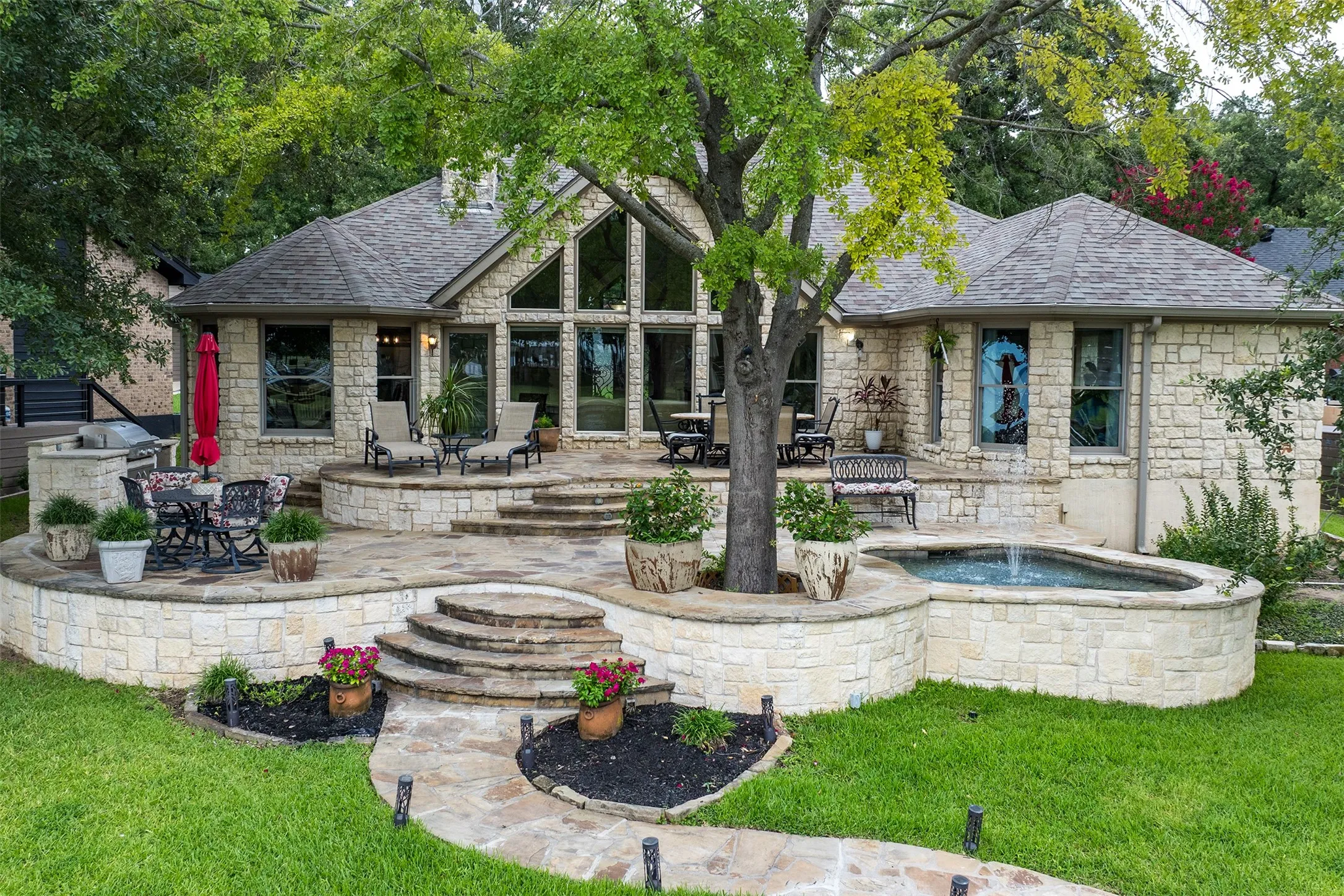 Exterior stone facade home featuring a multi-level flagstone patio with integrated water feature