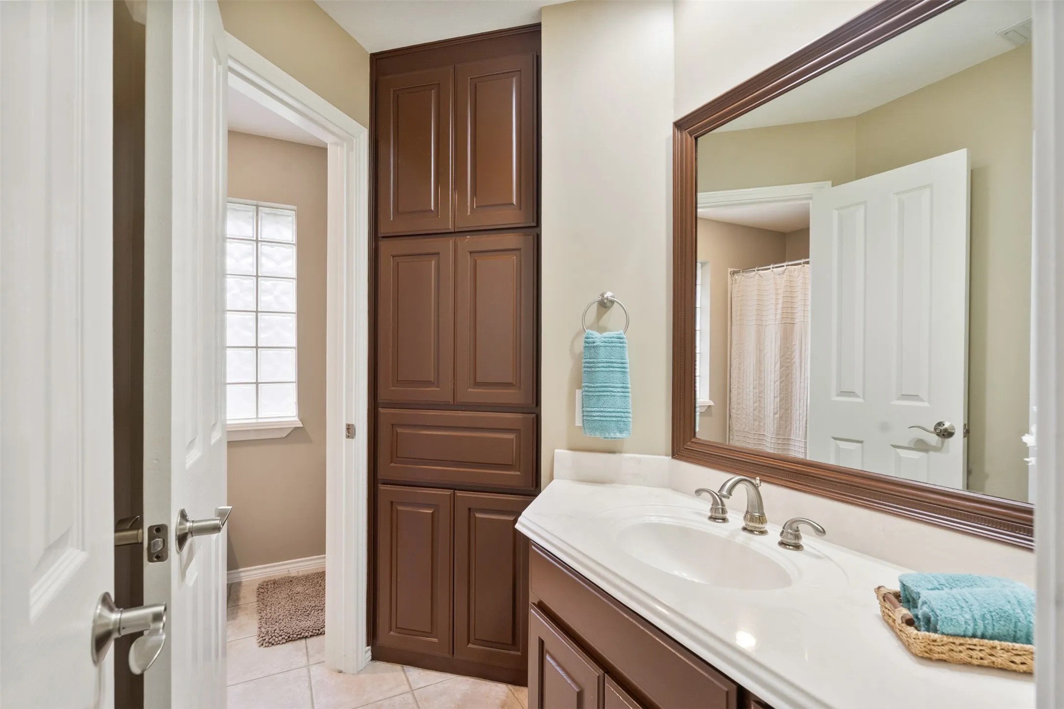 Bathroom vanity featuring an integrated sink, brushed nickel faucet, and a quartz countertop