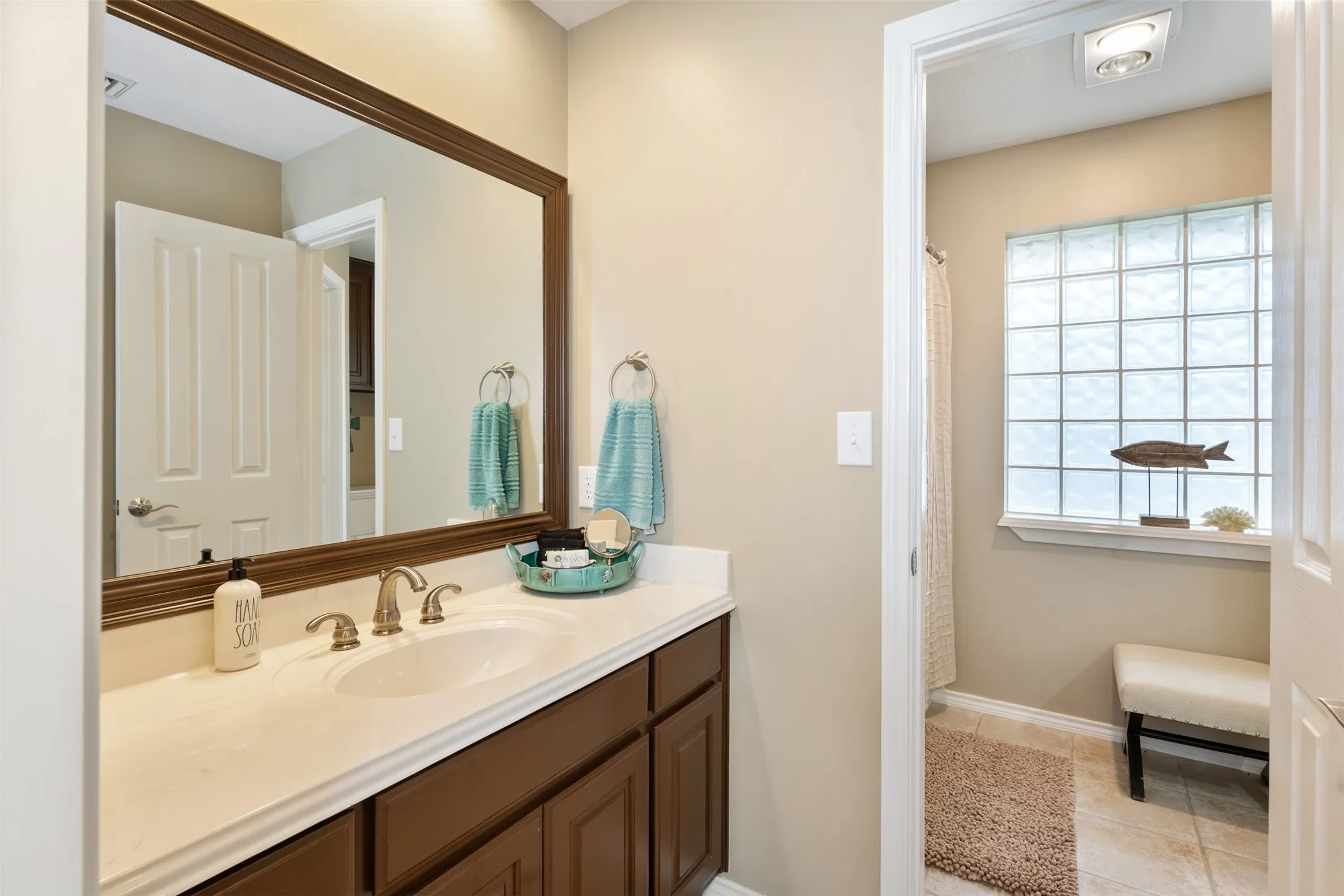 Bathroom vanity with undermount sink, brushed nickel faucet, and a framed mirror