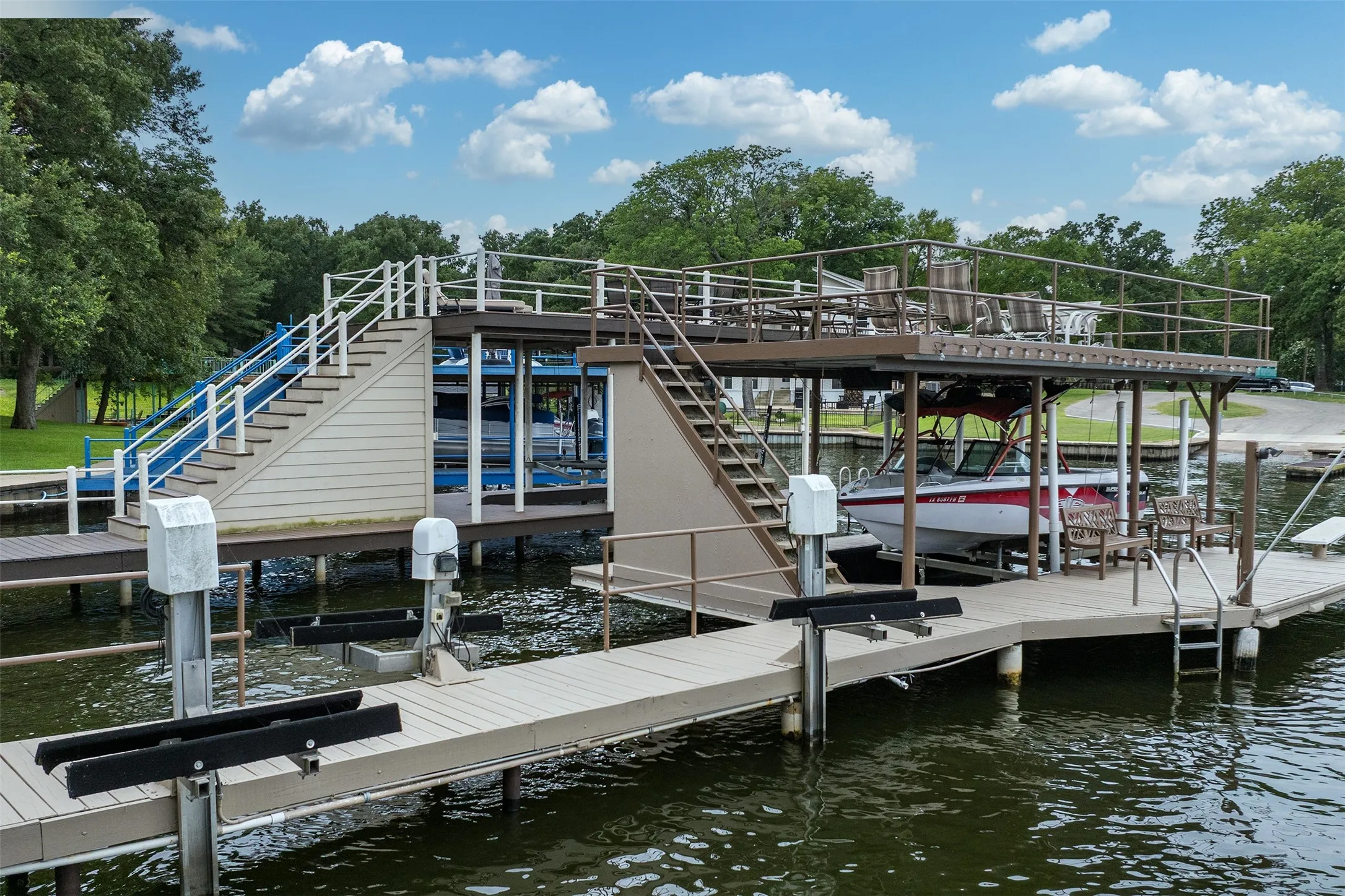 Multi-level boat dock featuring two boat slips, a covered upper deck, and durable composite decking
