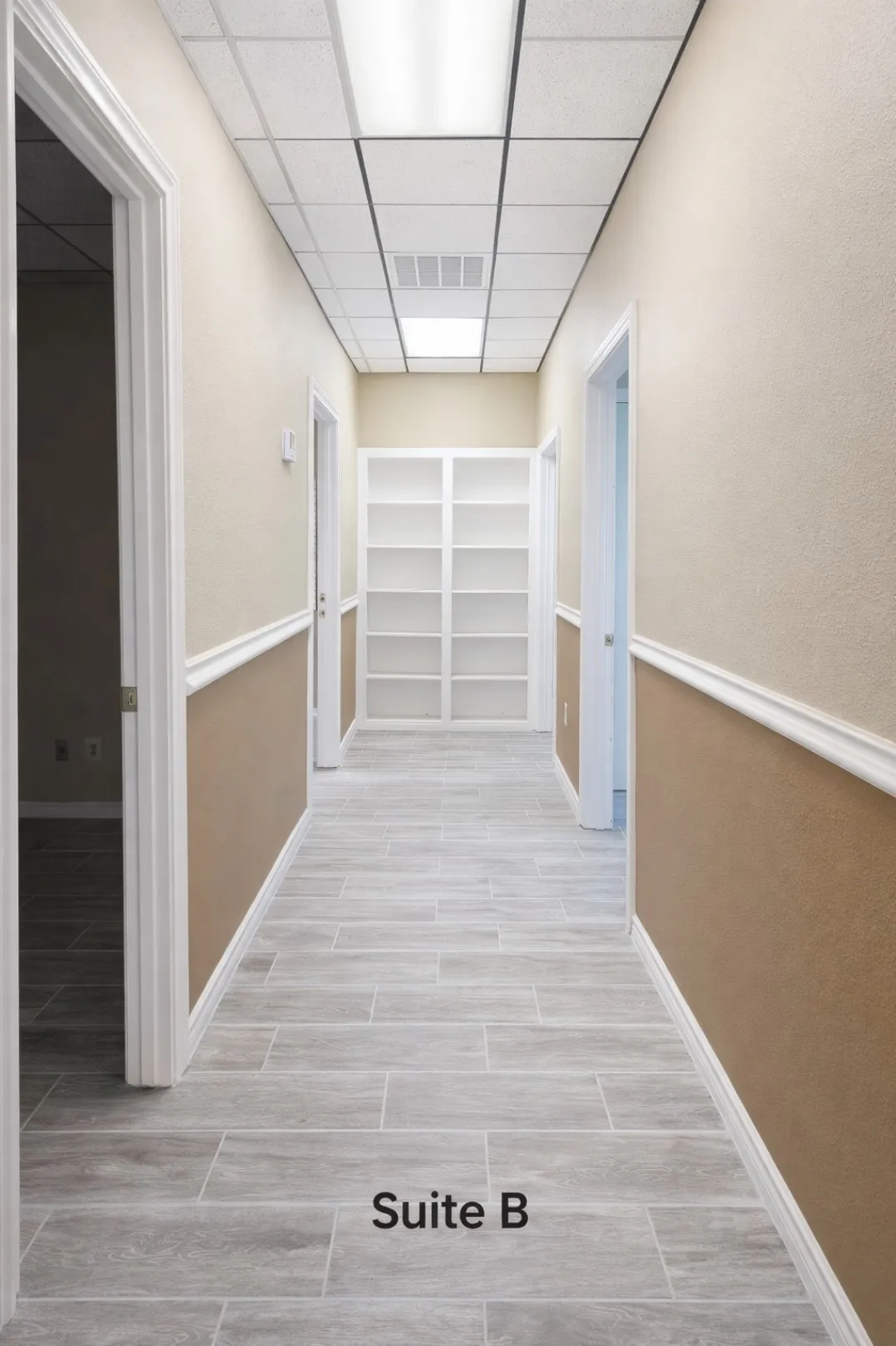 Hallway featuring wood-look tile flooring, two-tone wall paint, white crown molding, recessed lighting, and built-in shelving