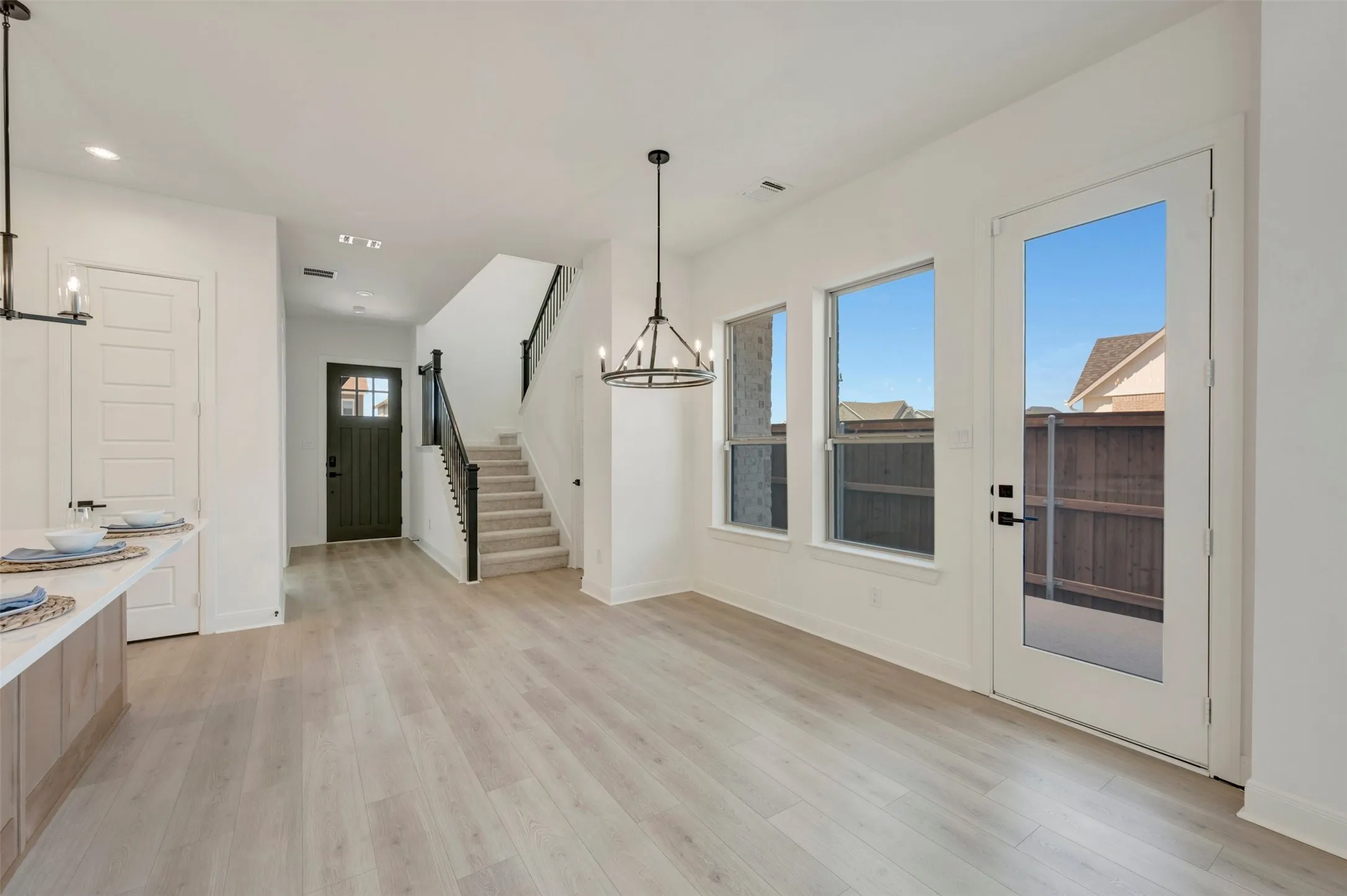 Wood-finish flooring, white walls, and a contemporary chandelier