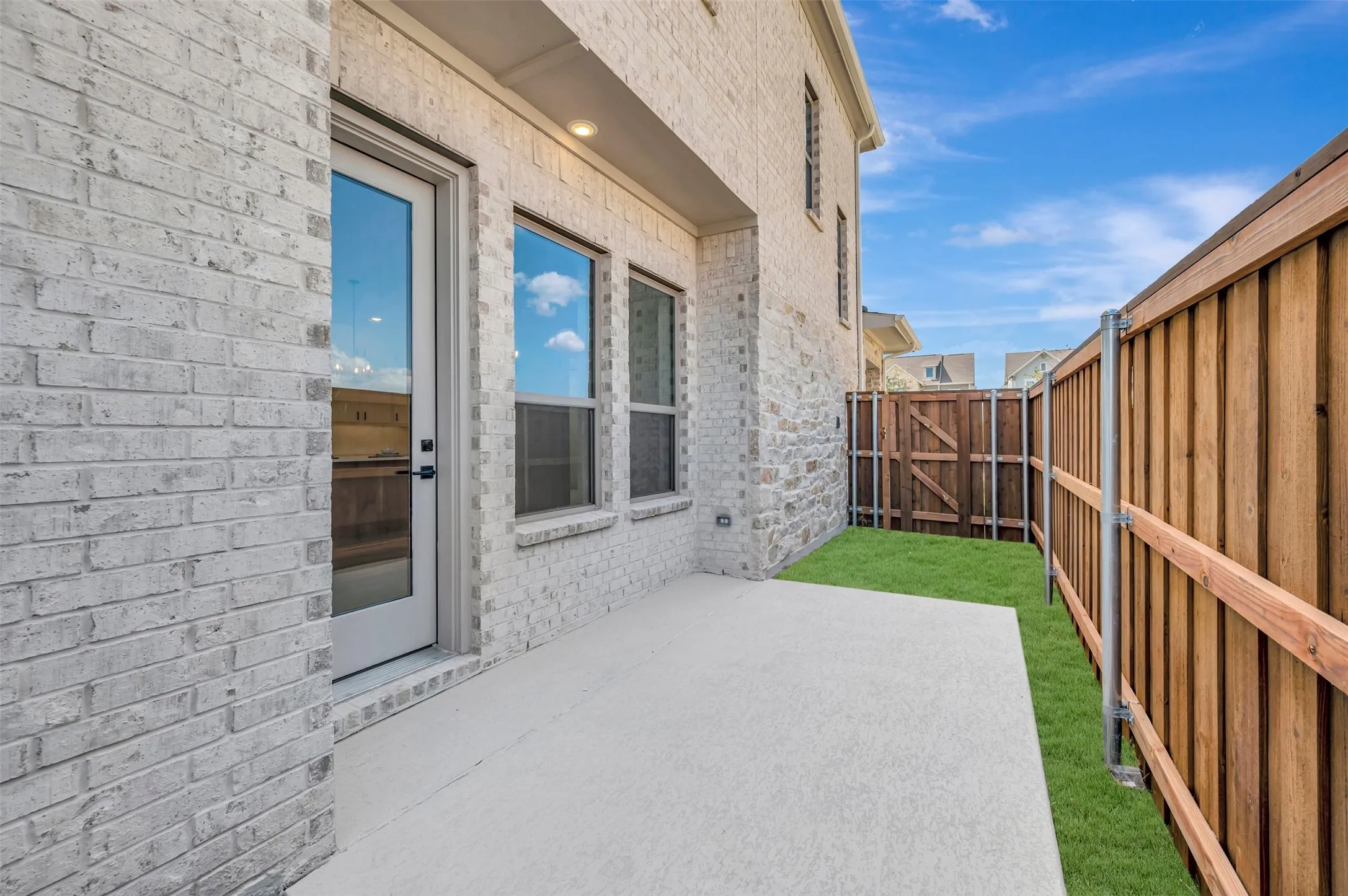 White brick exterior with a concrete patio