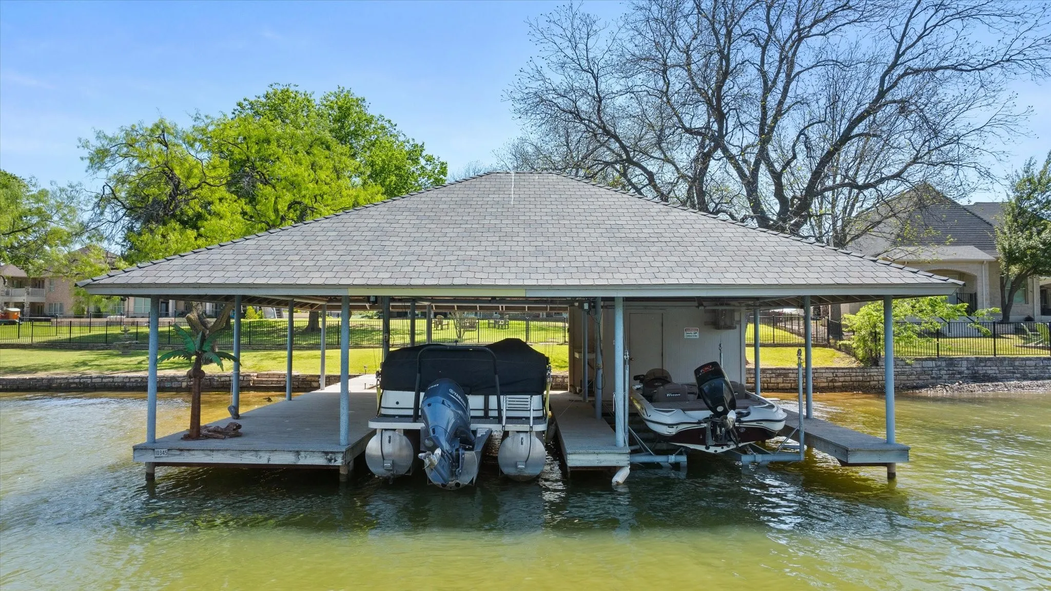 Covered boat dock featuring two boat slips and an additional storage area