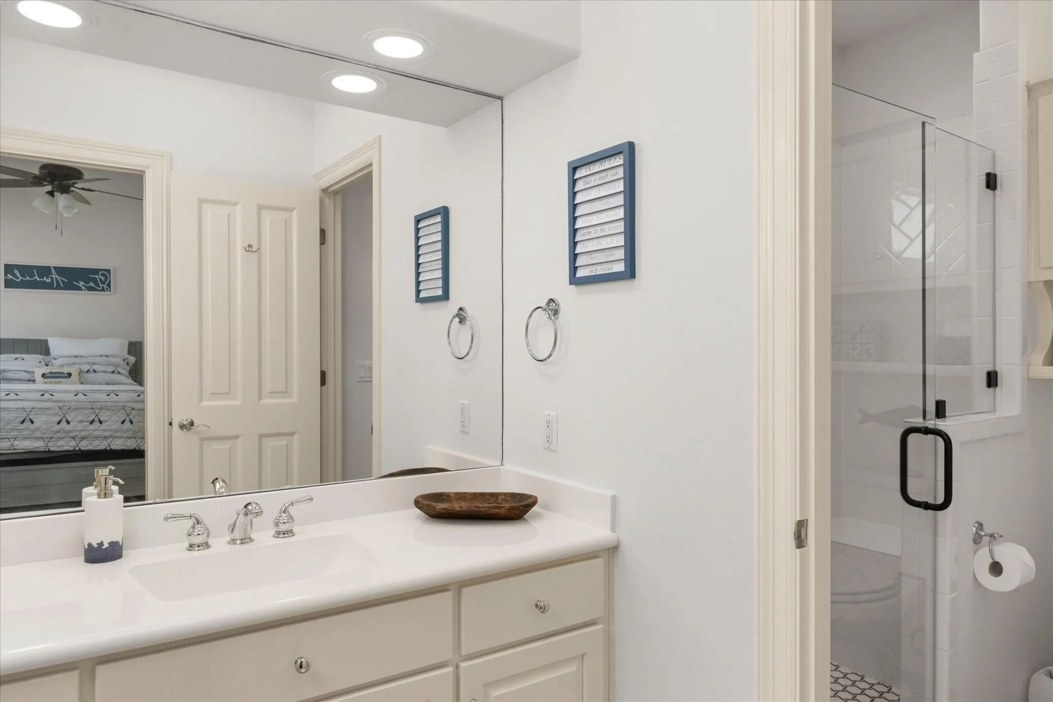 Bathroom vanity with an integrated sink, polished chrome faucet, and expansive wall-mounted mirror