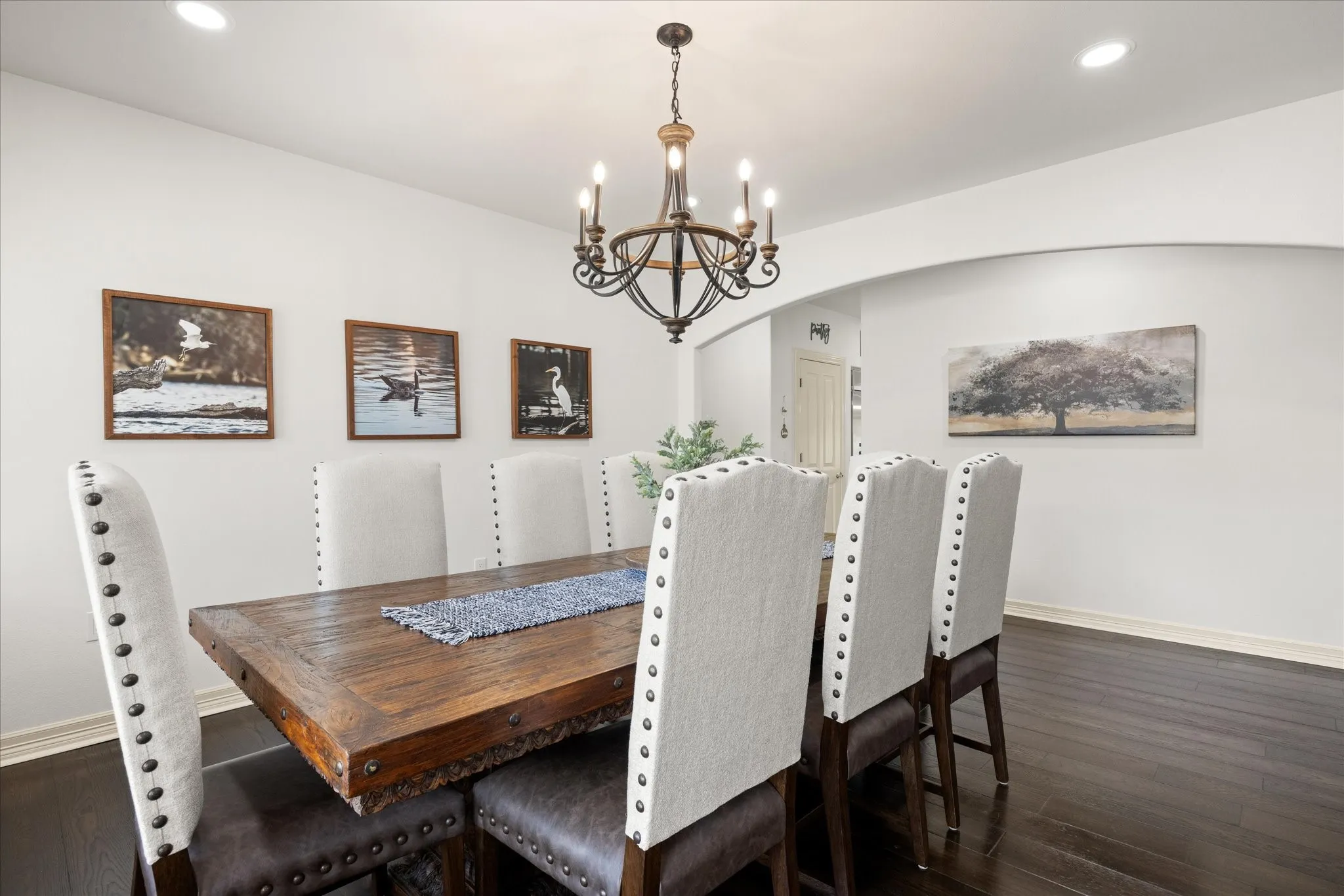 Formal dining area featuring dark wood-finish flooring, recessed lighting, and a substantial wrought iron chandelier