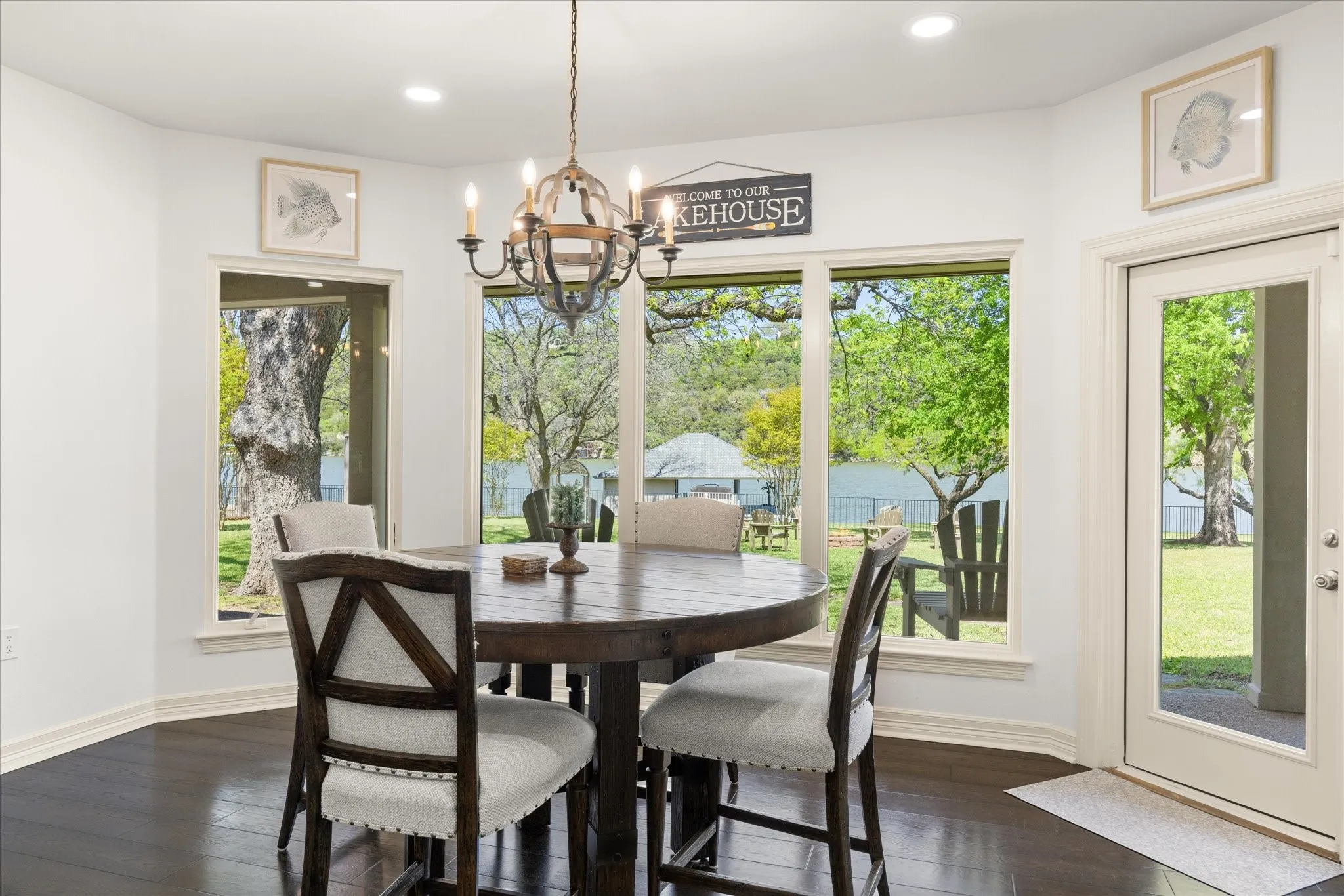 Dining area featuring a dark wood-finish round table, upholstered chairs, and dark wood-finish flooring