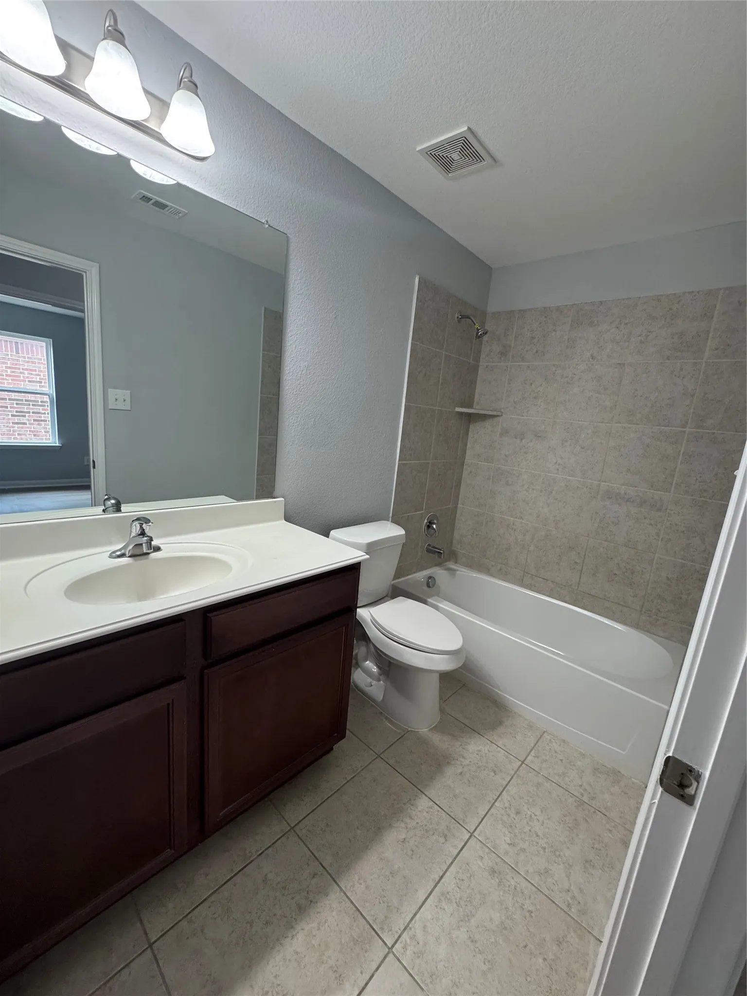 Bathroom featuring a dark wood-finish vanity with a white countertop and integrated sink