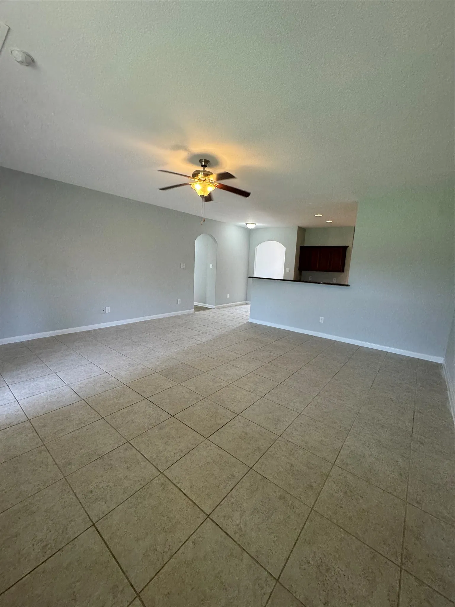 Spacious interior featuring neutral wall tones and large format tile flooring