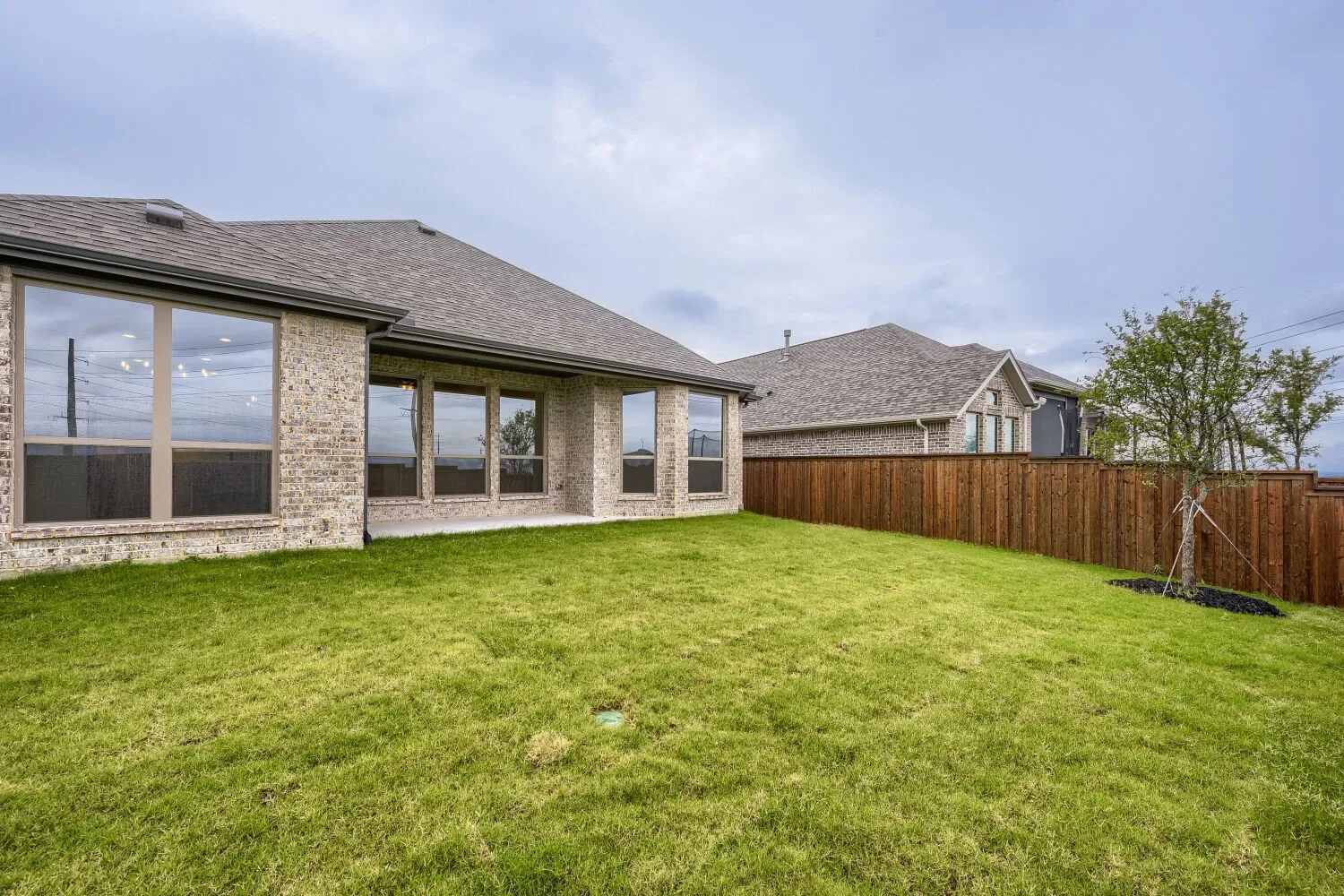 Expansive grassy yard featuring a new privacy fence