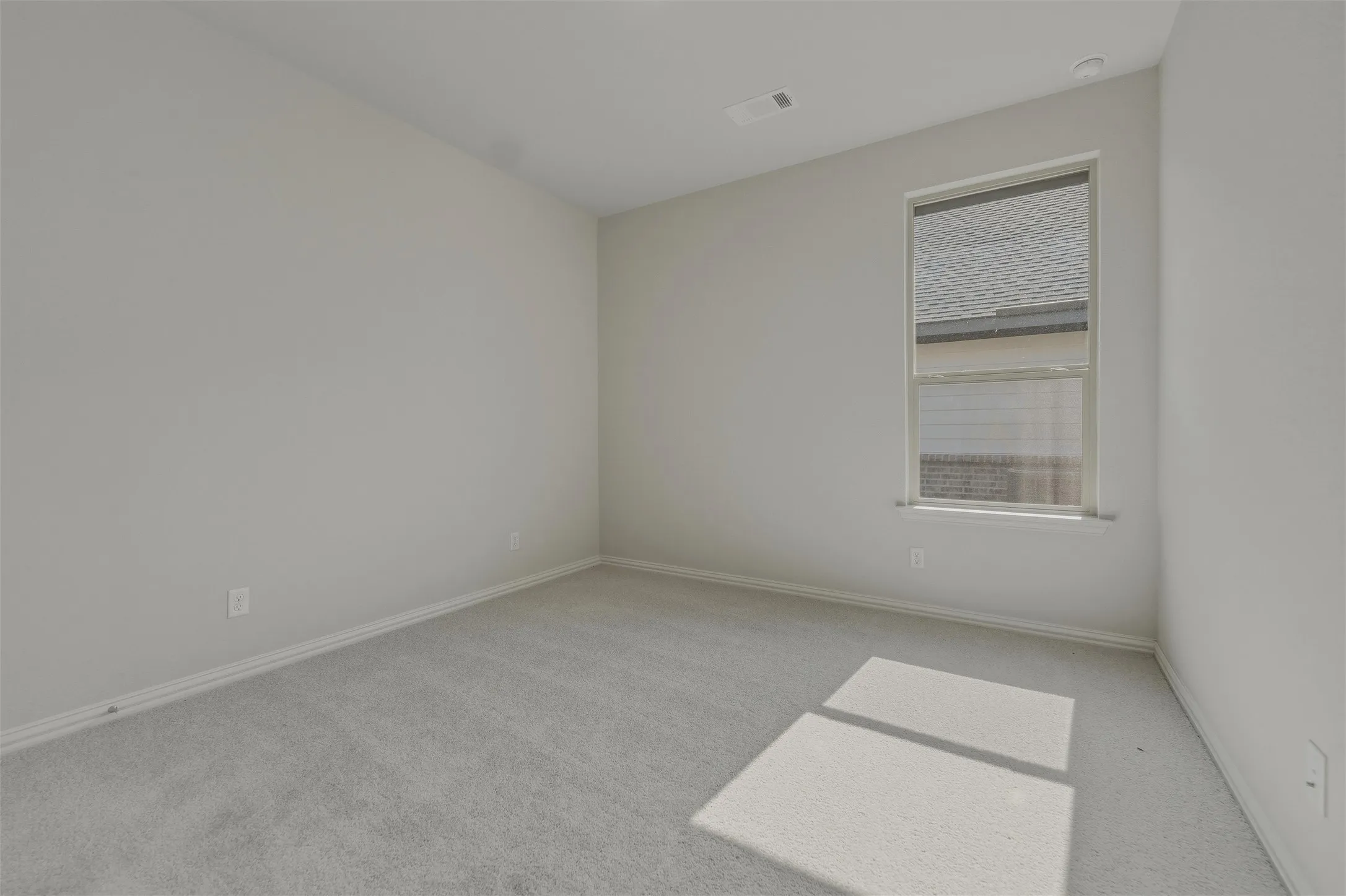 Neutral paint tones throughout, gray carpeting, recessed ceiling light, and a window with blinds