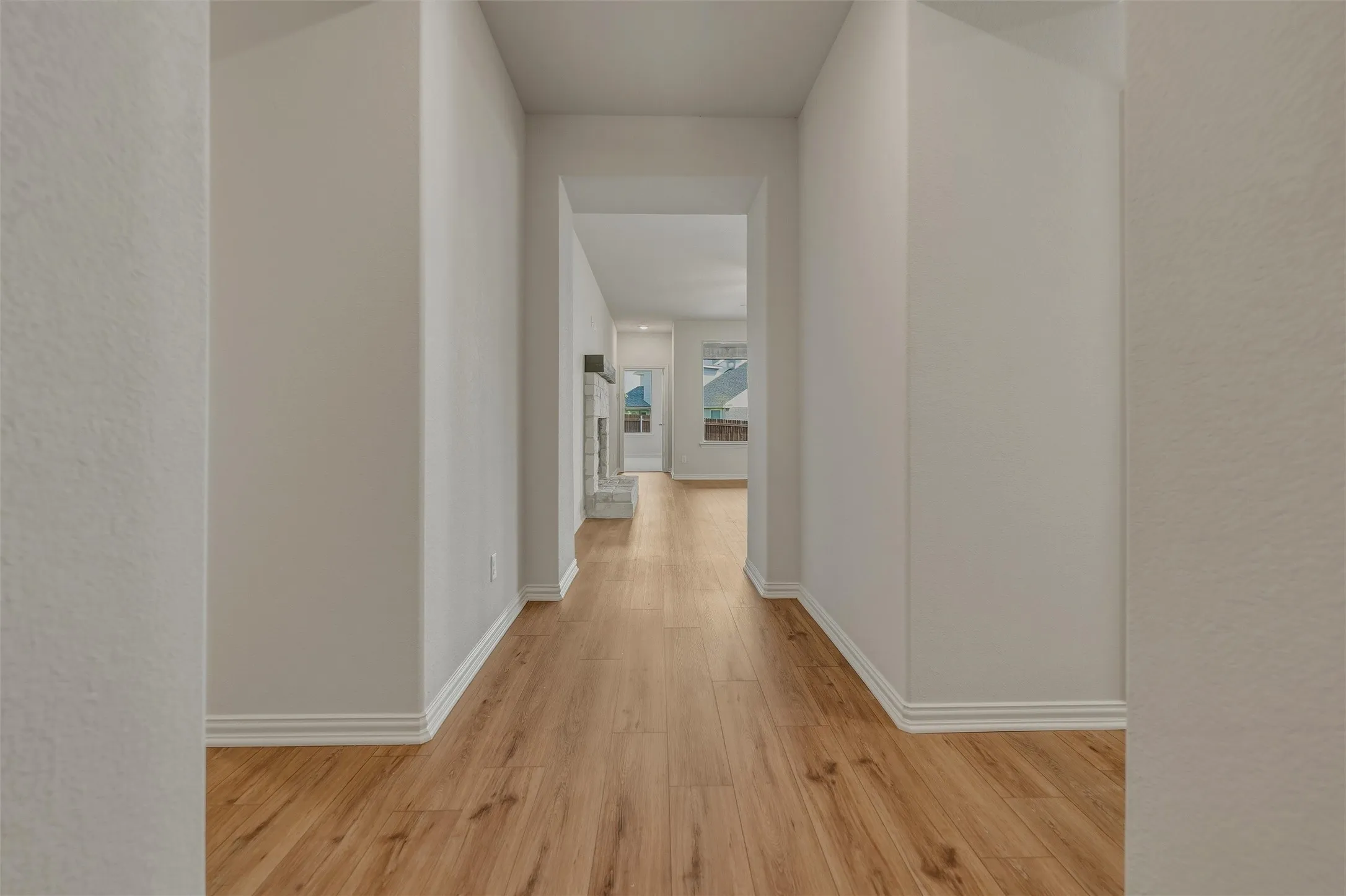 Wood-finish flooring throughout, bright white walls, and a recessed ceiling