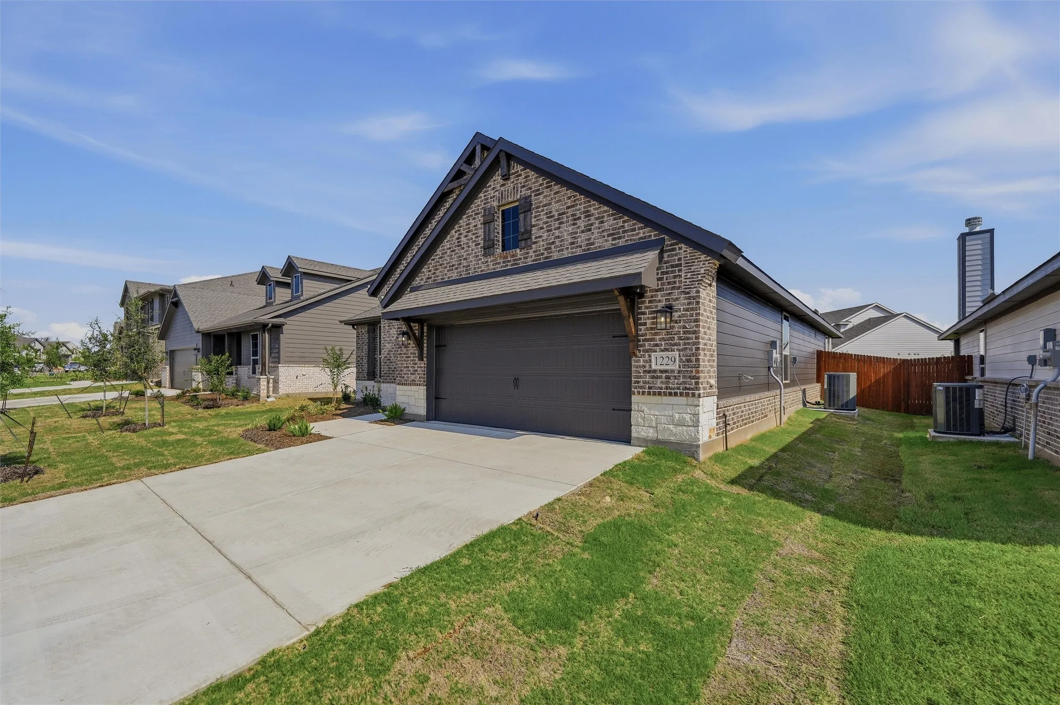 Contemporary single-story residence featuring a brick and siding exterior, an attached garage, and a concrete driveway