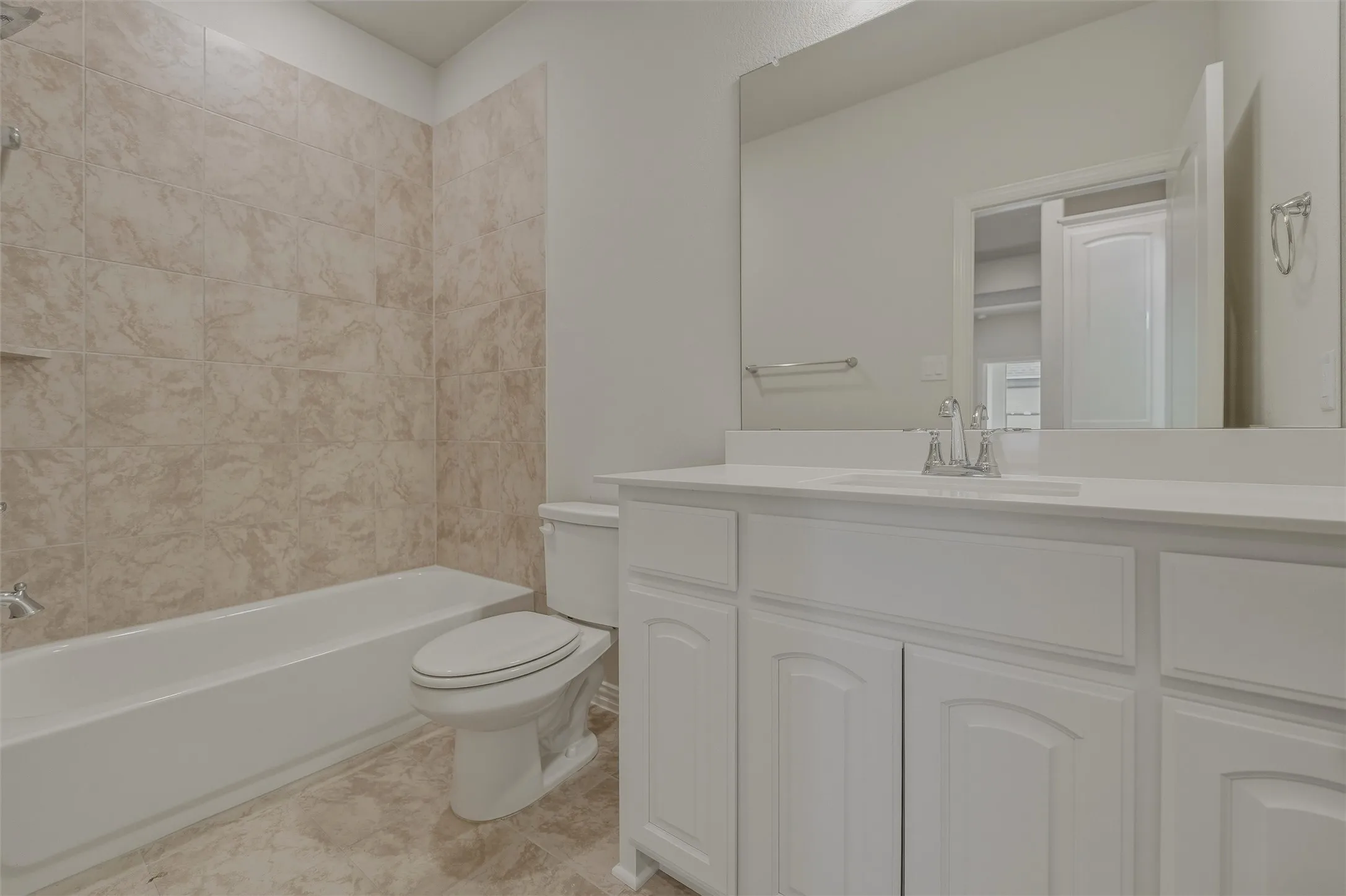 White vanity with dual sinks, a large integrated mirror, and chrome fixtures