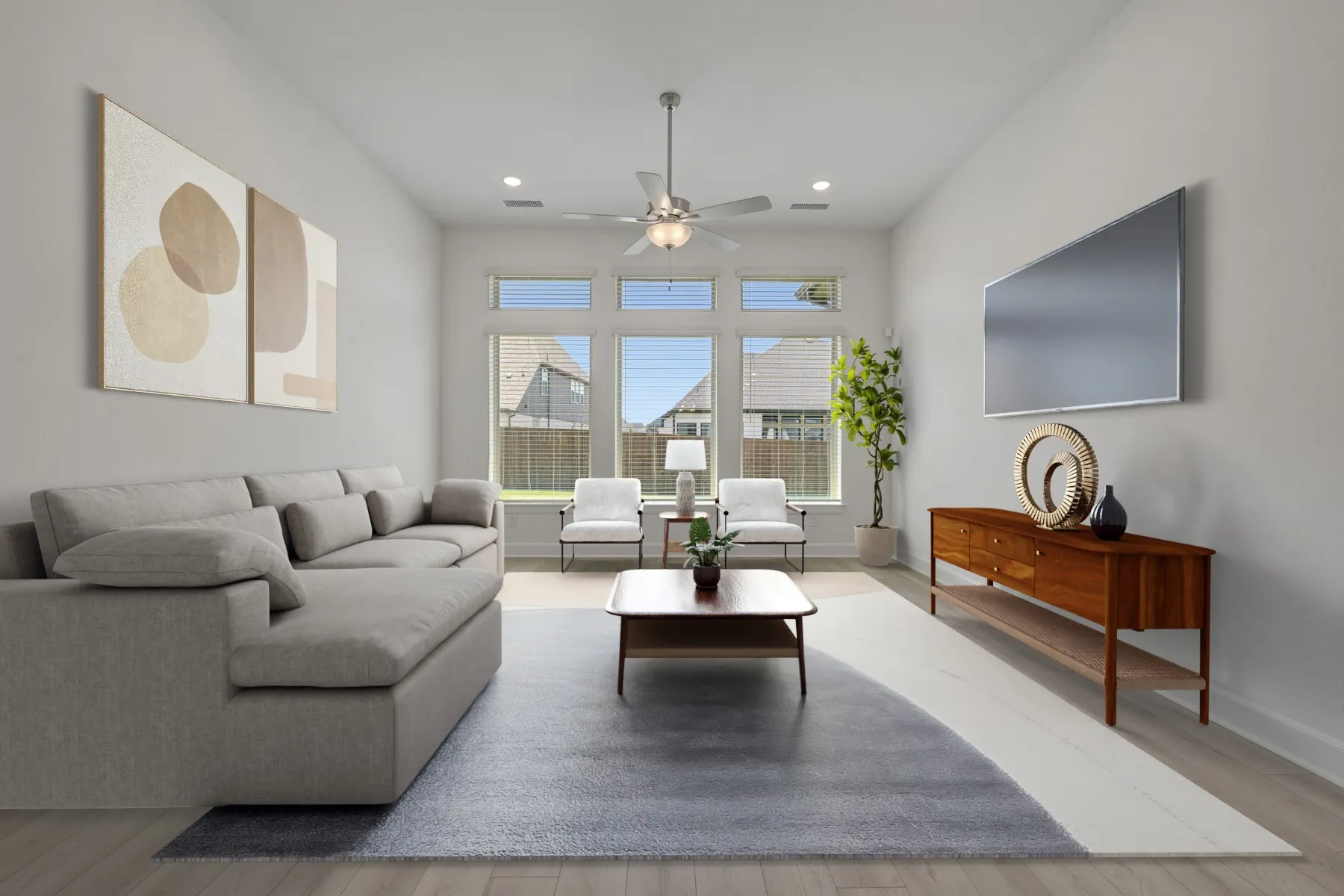 Spacious living area featuring light wood-finish flooring, a contemporary ceiling fan, recessed lighting, and a wall-mounted television