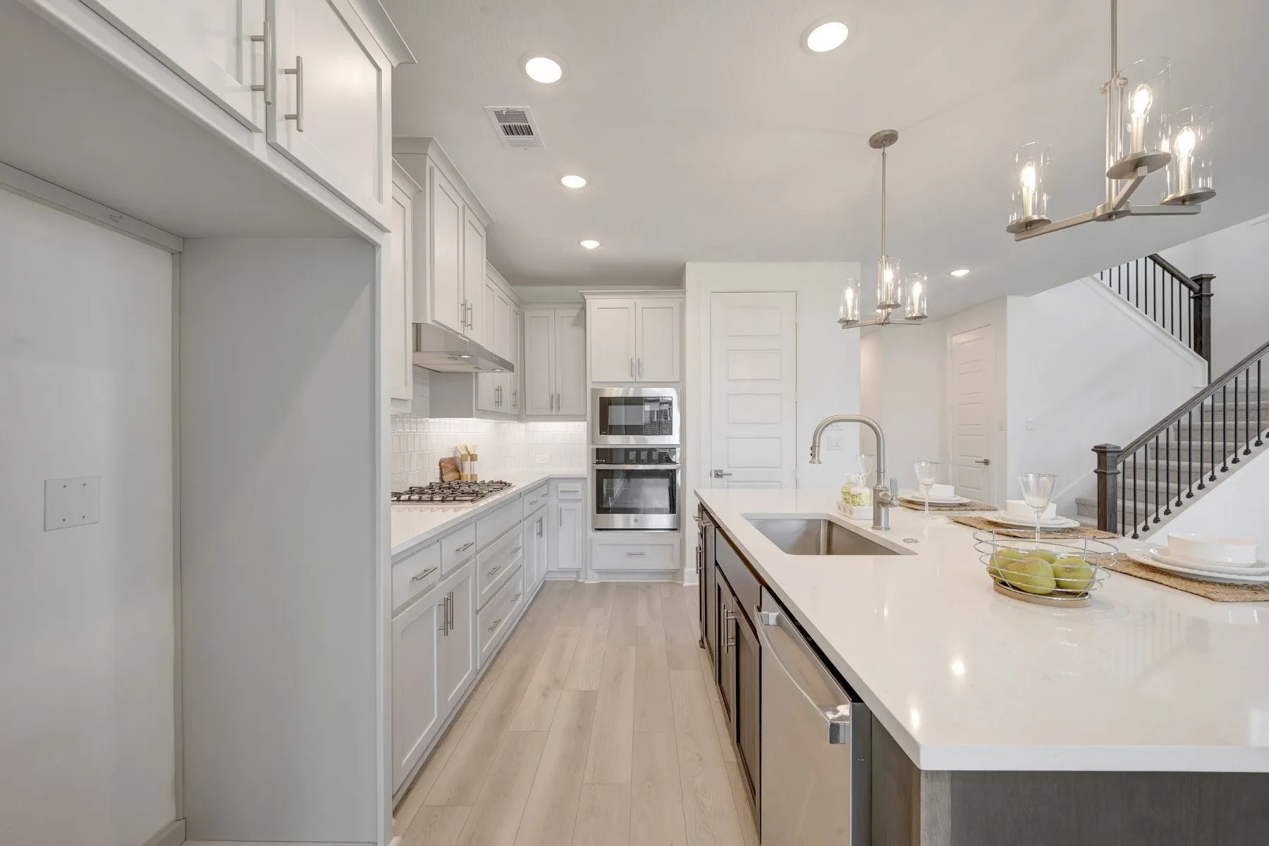 Modern kitchen featuring light cabinetry, stainless steel appliances, a center island with sink and integrated dishwasher, and recessed lighting