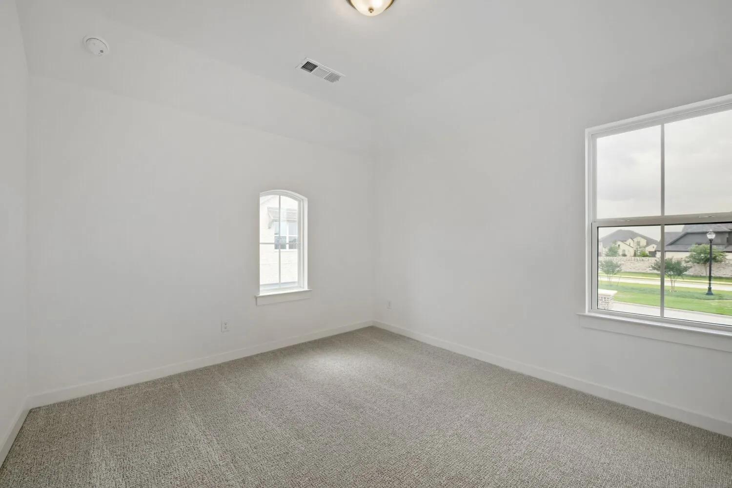 Neutral wall finishes, recessed ceiling light fixture, and contemporary carpet flooring