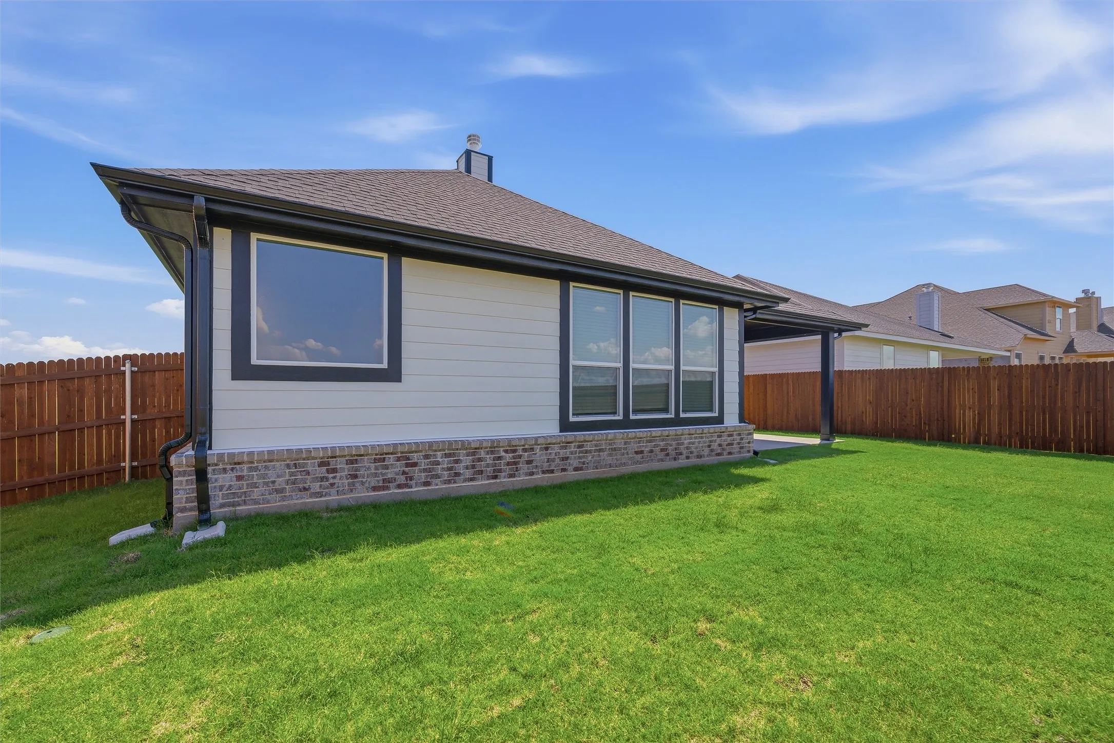 Expansive green lawn bordering the rear exterior