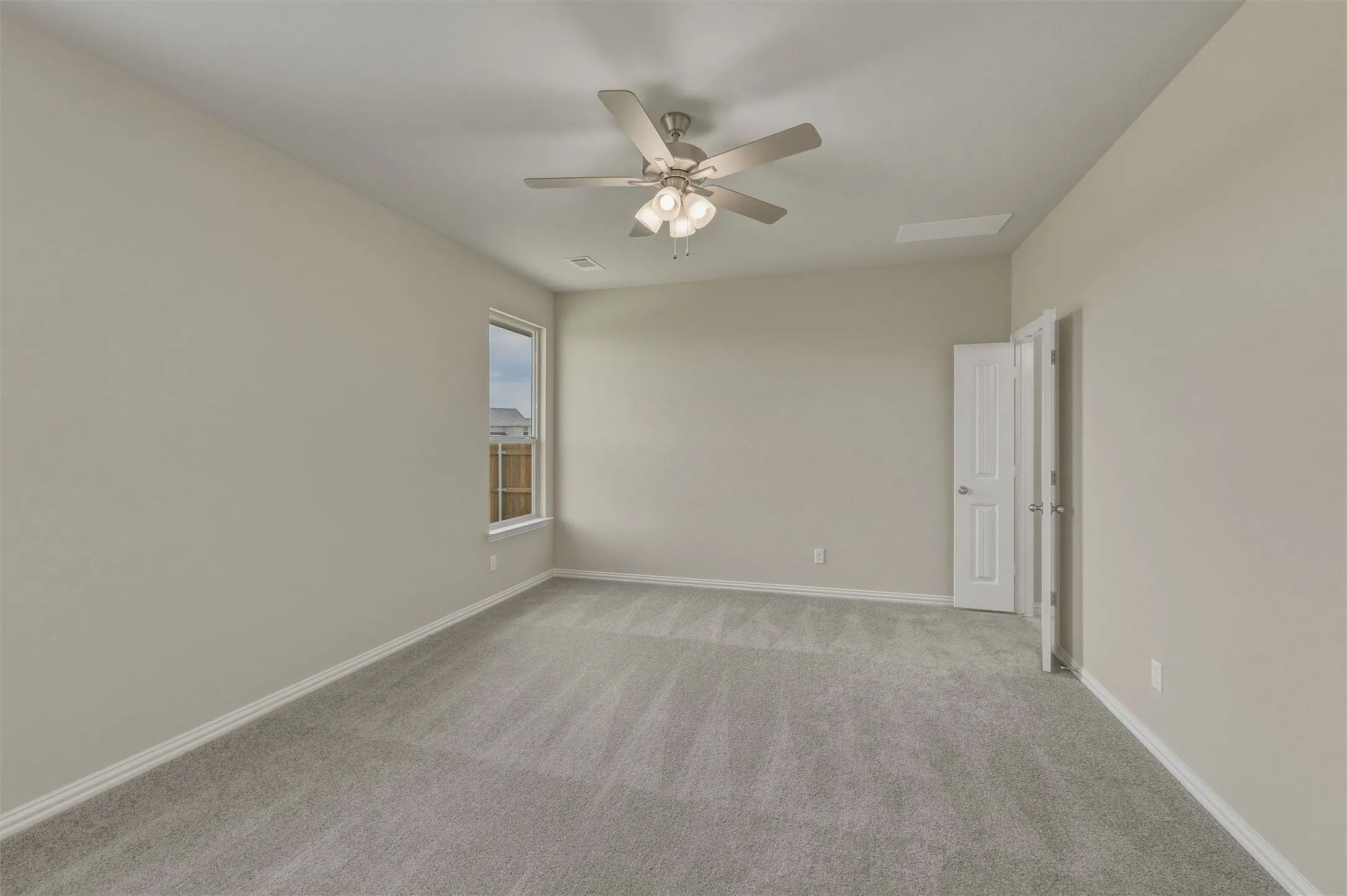 Carpeted room featuring a ceiling fan with integrated lighting, a single window, and a white paneled door