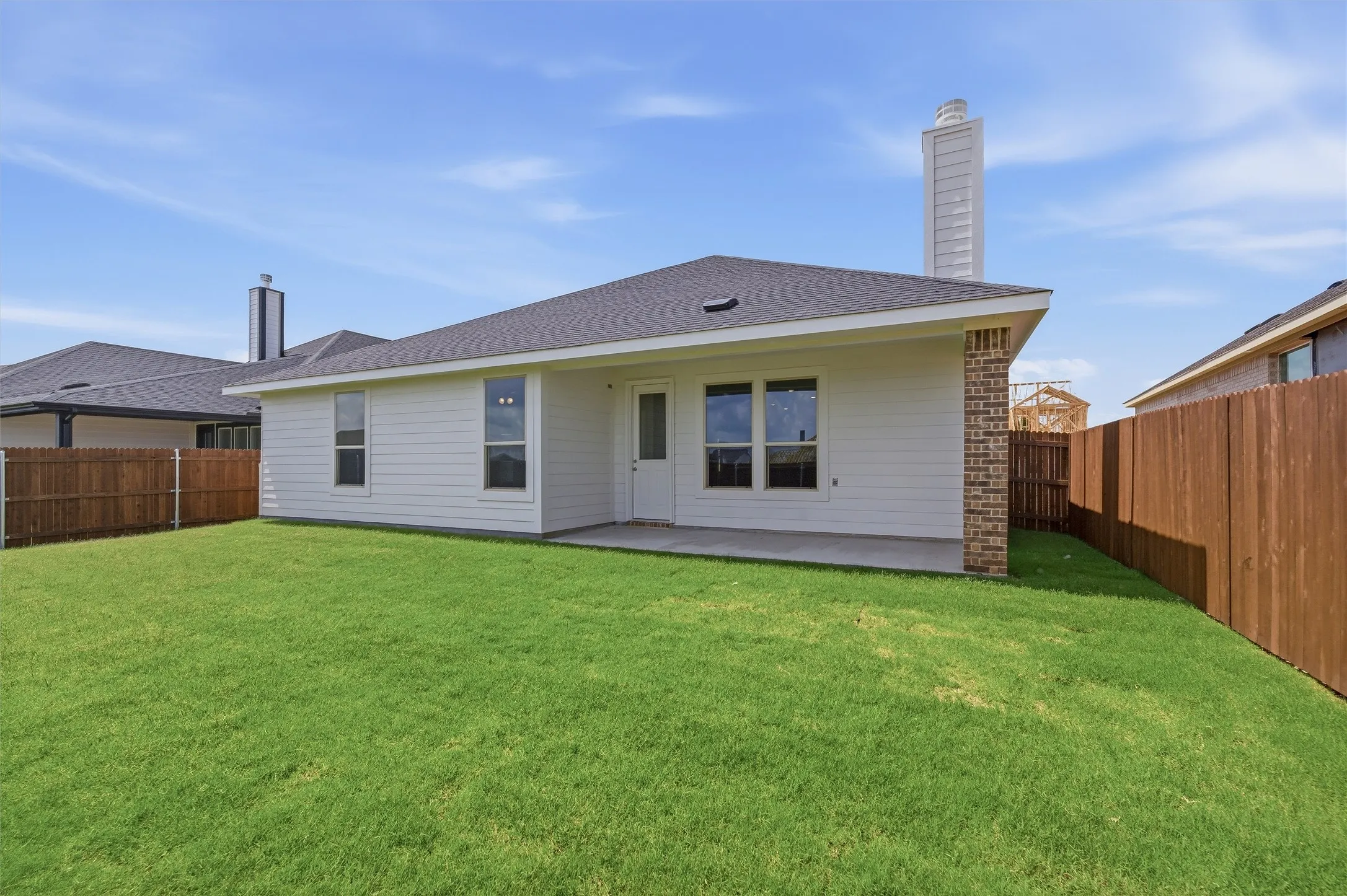 Expansive green lawn surrounds the rear of the property