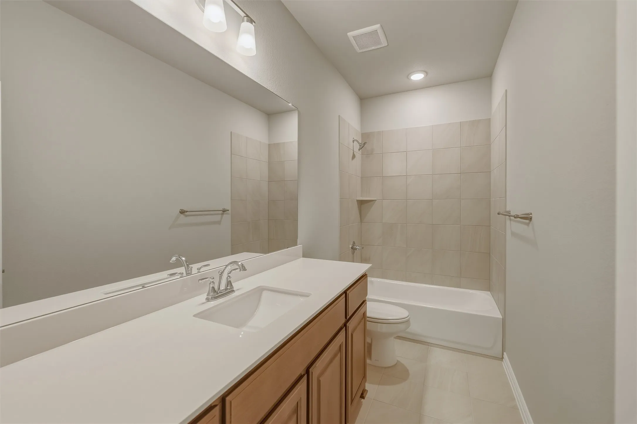 Full bathroom featuring an integrated sink, wood-finish vanity, and a rectangular mirror